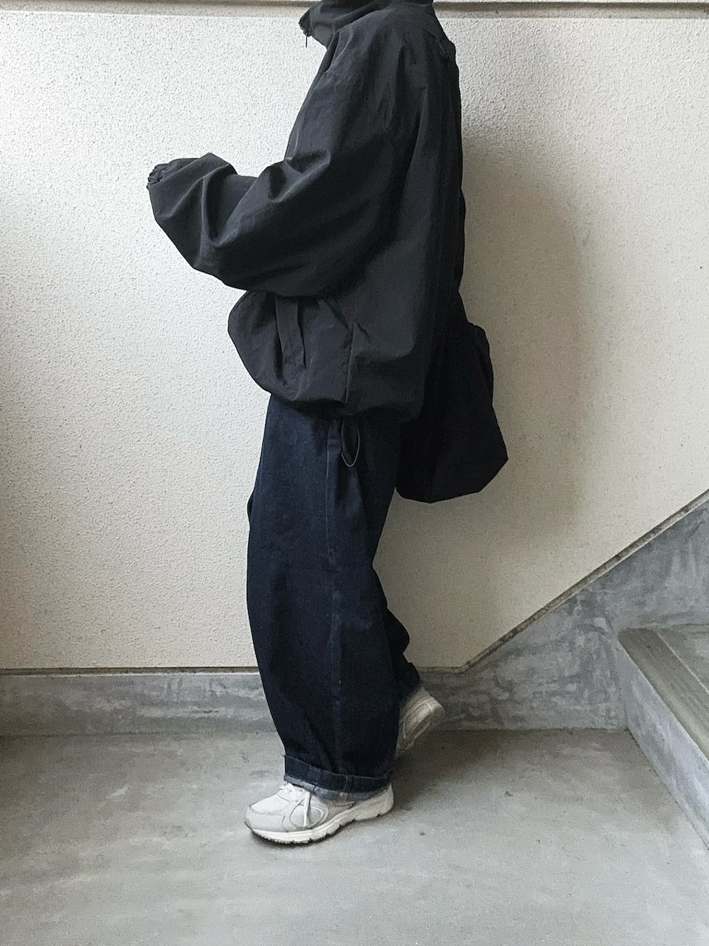 ブラック系のナイロンジャケット、ブルー系のデニムパンツ、ホワイト系のTシャツ/カットソーを着用したレディースの春コーディネートの4枚目の写真