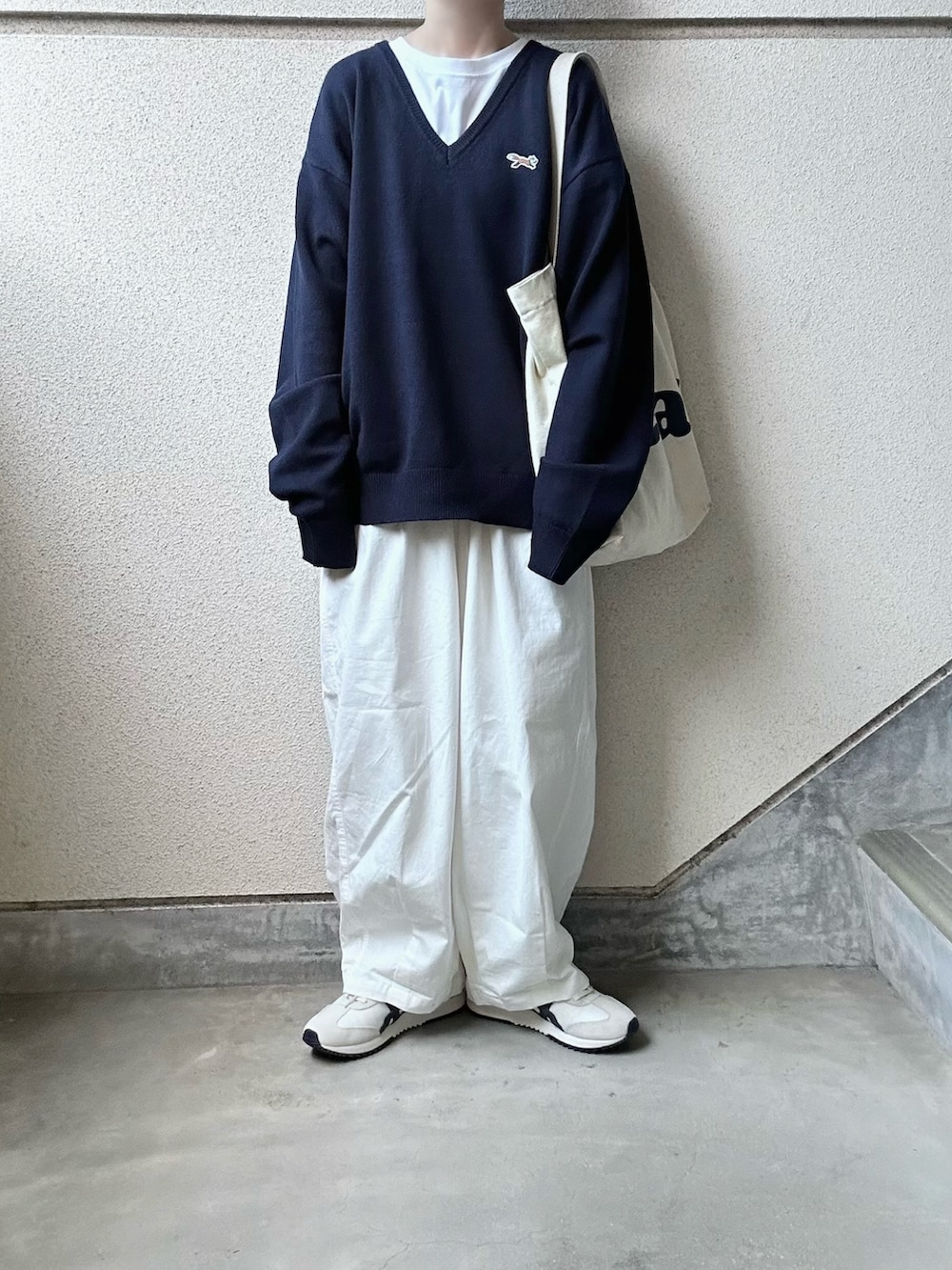 ブルー系のニット/セーター、ホワイト系のチノパンツ、ベージュ系のスニーカーを着用したレディースの秋コーディネートの5枚目の写真
