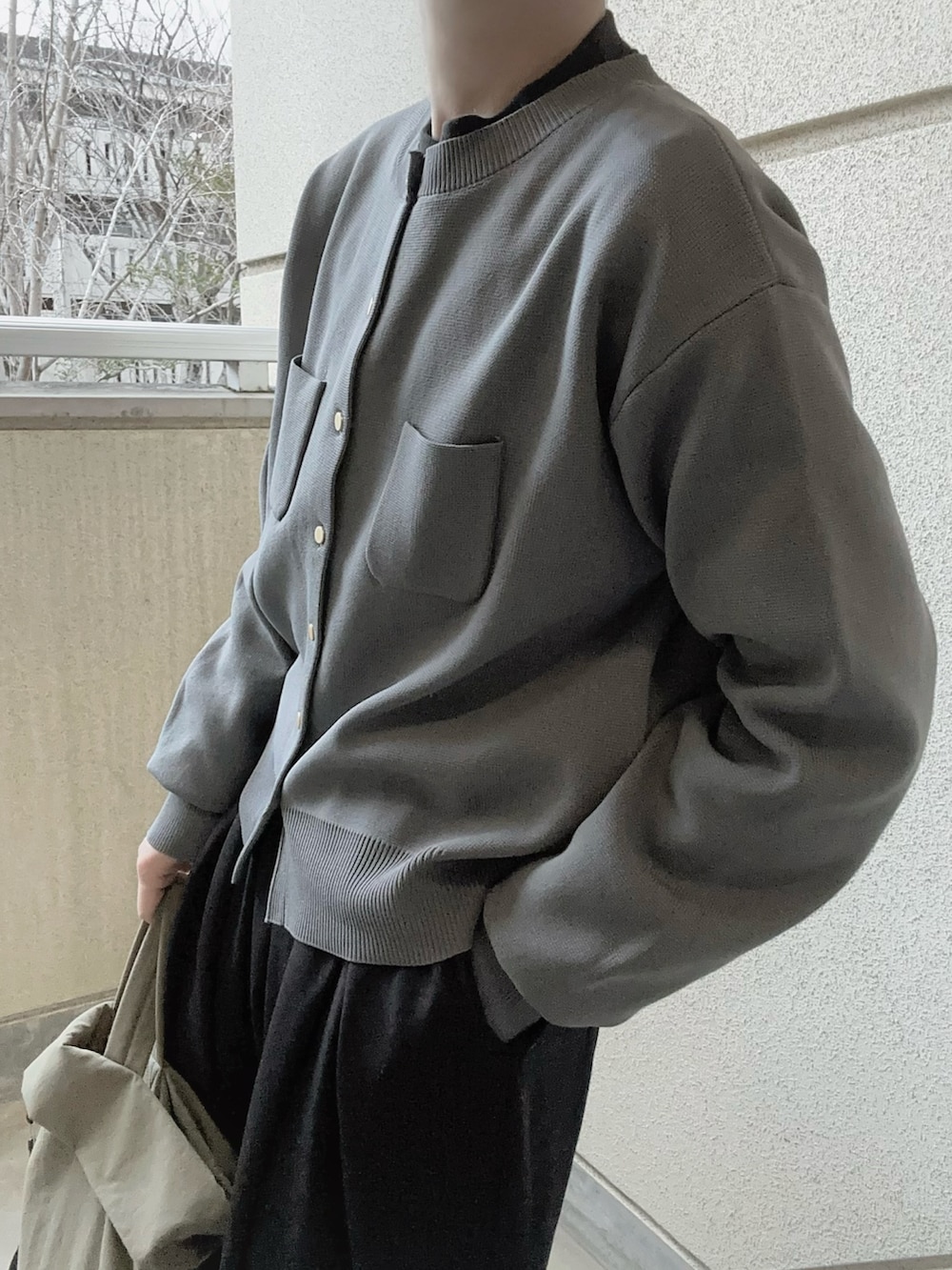 グレー系のカーディガン/ボレロ、ブラック系のスラックス、グリーン系のトートバッグを着用したレディースの冬コーディネートの4枚目の写真