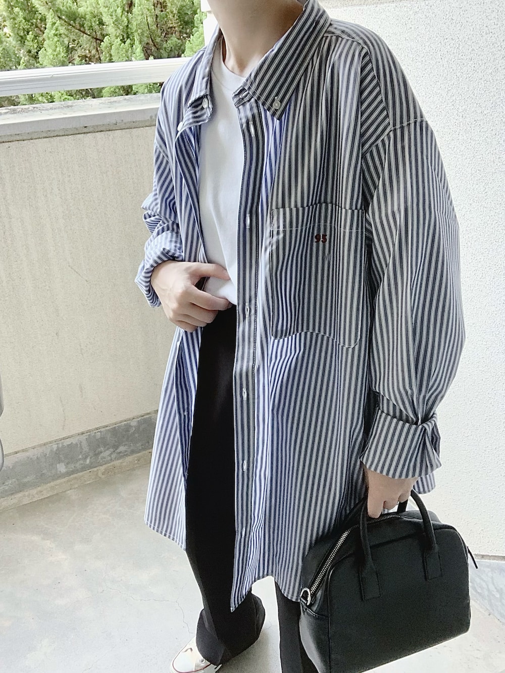 ブルー系のシャツ/ブラウス、ブラック系のスラックス、ホワイト系のスニーカーを着用したレディースの夏コーディネートの3枚目の写真