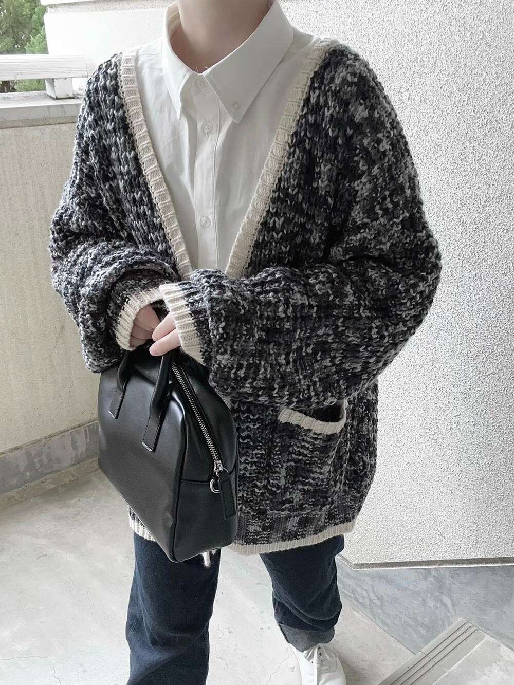 ブラック系のカーディガン/ボレロ、ホワイト系のシャツ/ブラウス、ブルー系のデニムパンツを着用したレディースの冬コーディネートの3枚目の写真