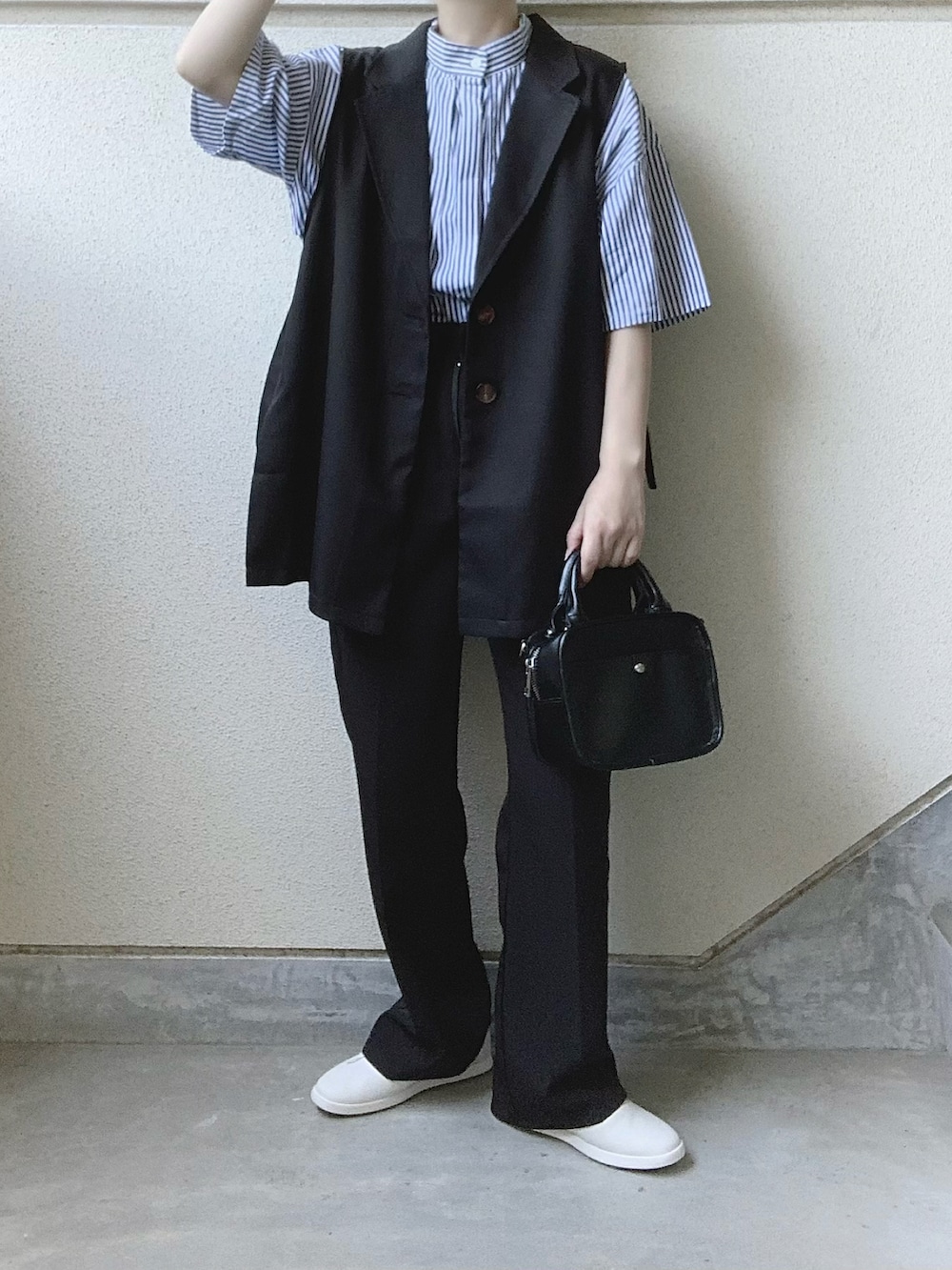 ブラック系のベスト、ブルー系のシャツ/ブラウス、ブラック系のスラックスを着用したレディースの夏コーディネートの3枚目の写真