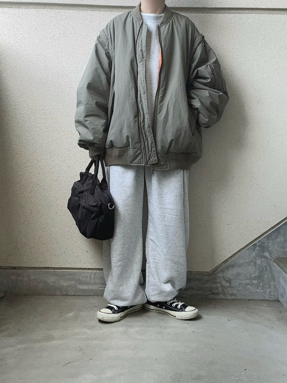 グレー系のスウェットパンツ、グレー系のスウェット、グリーン系のMA-1を着用したレディースの冬コーディネートの3枚目の写真