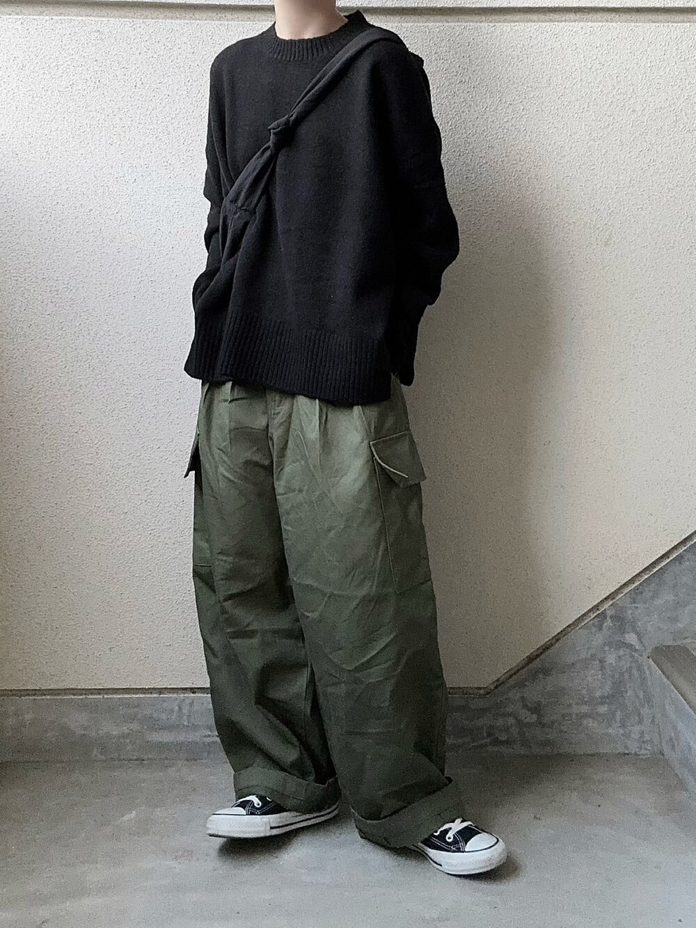 ブラック系のニット/セーター、グリーン系のカーゴパンツを着用したレディースの冬コーディネートの4枚目の写真