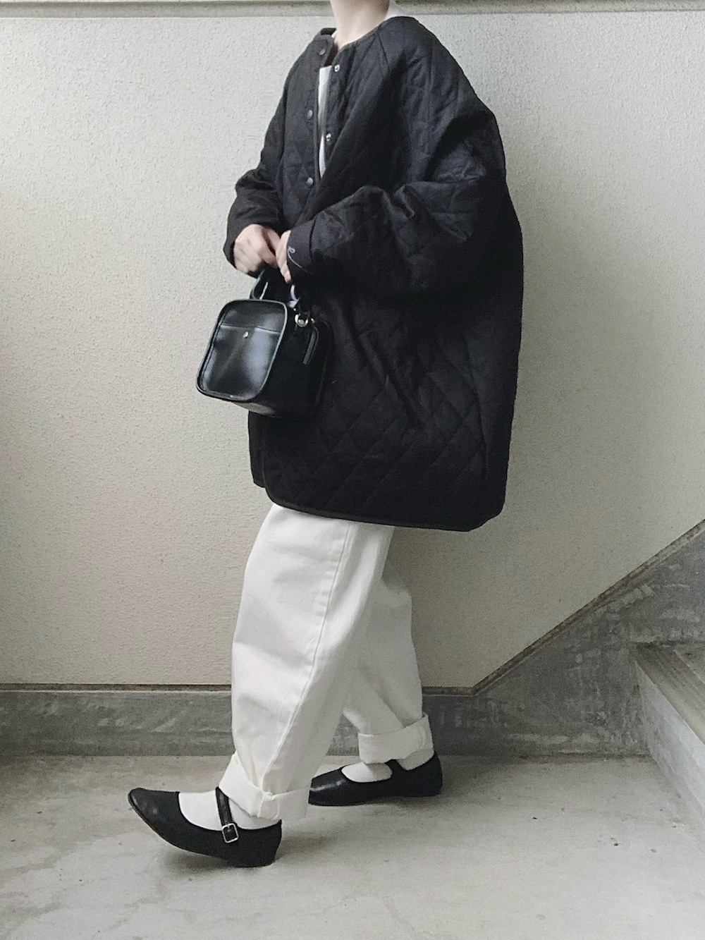 ブラック系のノーカラーコート、ホワイト系のシャツ/ブラウス、ホワイト系のデニムパンツを着用したレディースの秋コーディネートの2枚目の写真