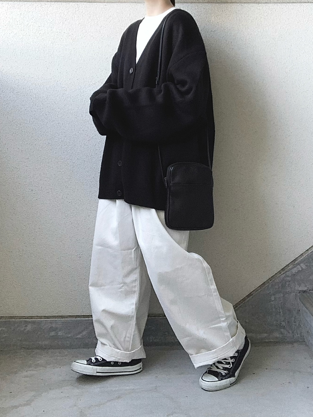 ベージュ系のチノパンツ、ブラック系のカーディガン/ボレロ、ホワイト系のTシャツ/カットソーを着用したレディースの秋コーディネートの3枚目の写真