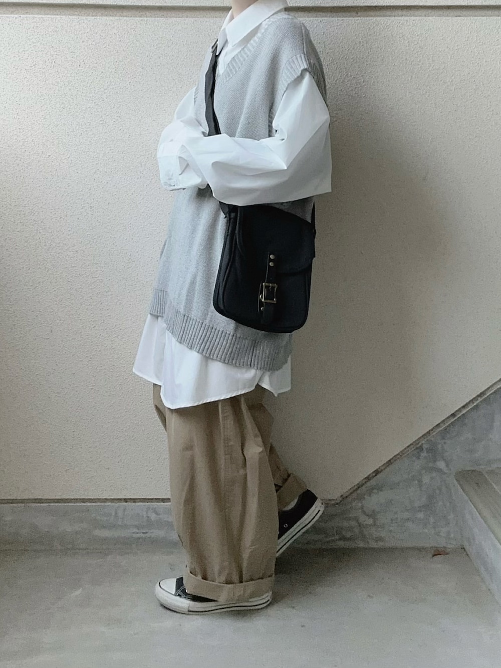 ホワイト系のシャツ/ブラウス、ブラック系のショルダーバッグ、ベージュ系のチノパンツを着用したレディースの冬コーディネートの3枚目の写真