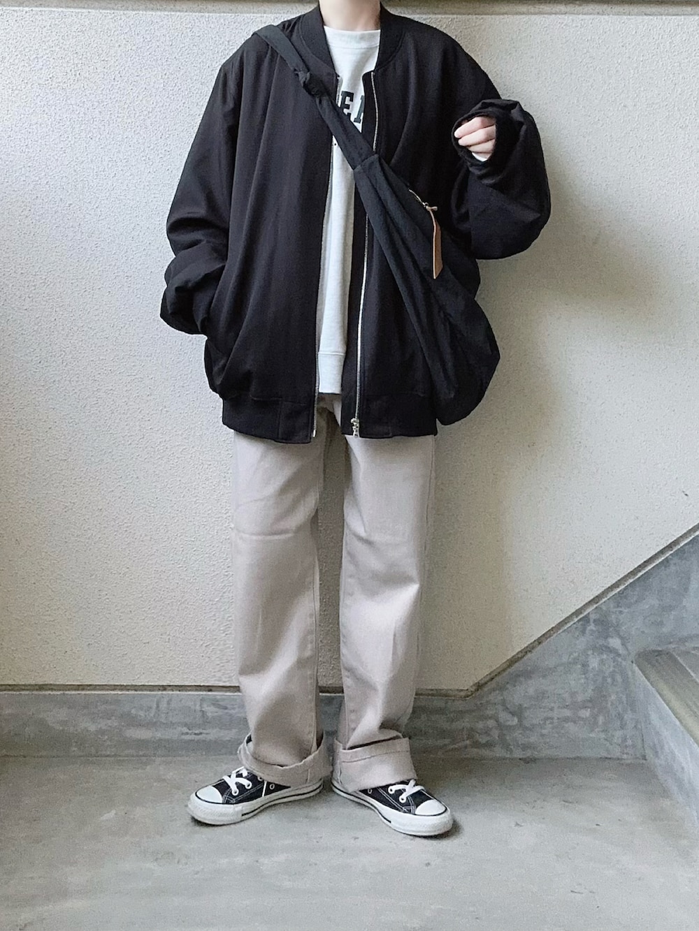 ブラック系のMA-1、ベージュ系のデニムパンツを着用したレディースの秋コーディネートの2枚目の写真