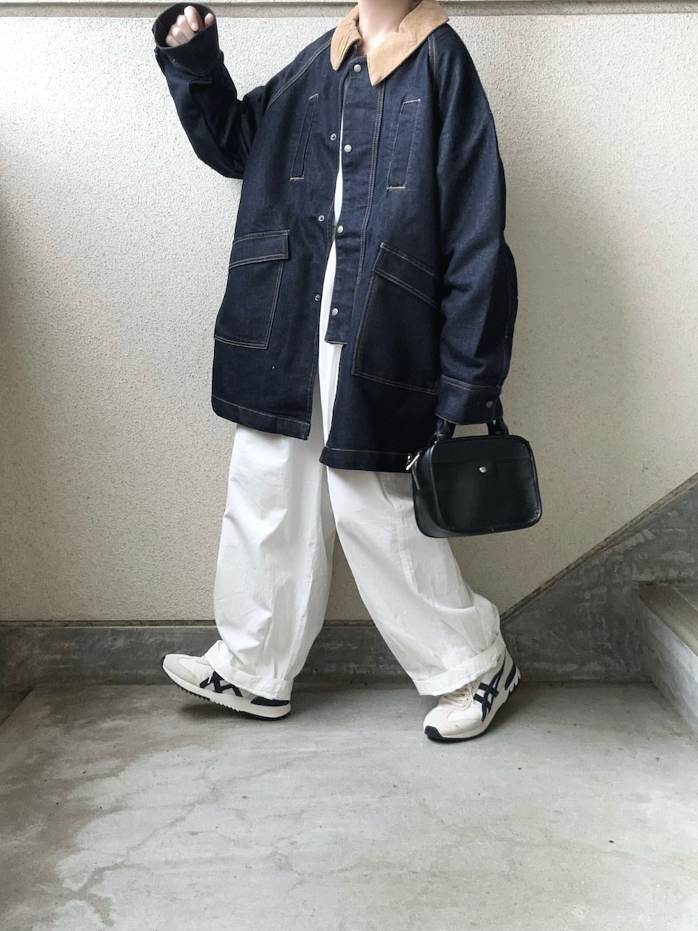ブルー系のデニムジャケット、ホワイト系のチノパンツ、ベージュ系のスニーカーを着用したレディースの秋コーディネートの2枚目の写真