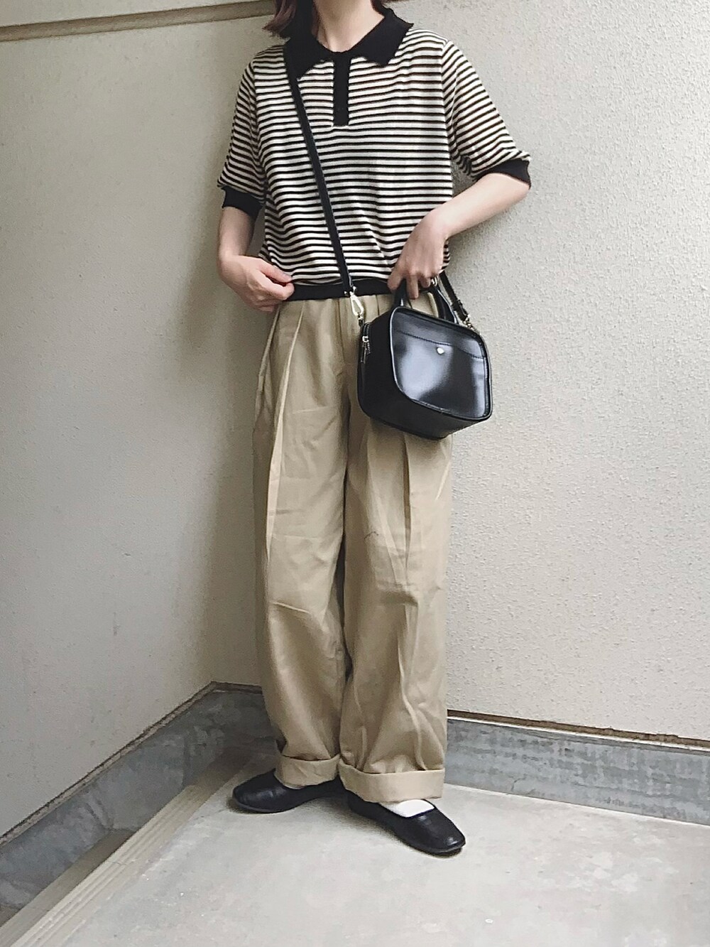 ブラック系のポロシャツ、ホワイト系のデニムパンツを着用したレディースの夏コーディネートの3枚目の写真