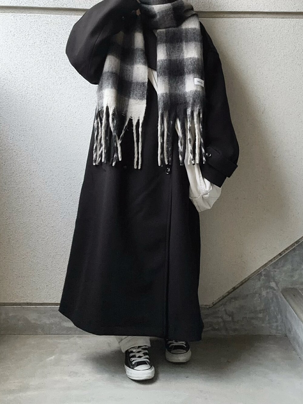 ブラック系のトレンチコート、ブラック系のマフラーを着用したレディースの冬コーディネートの3枚目の写真