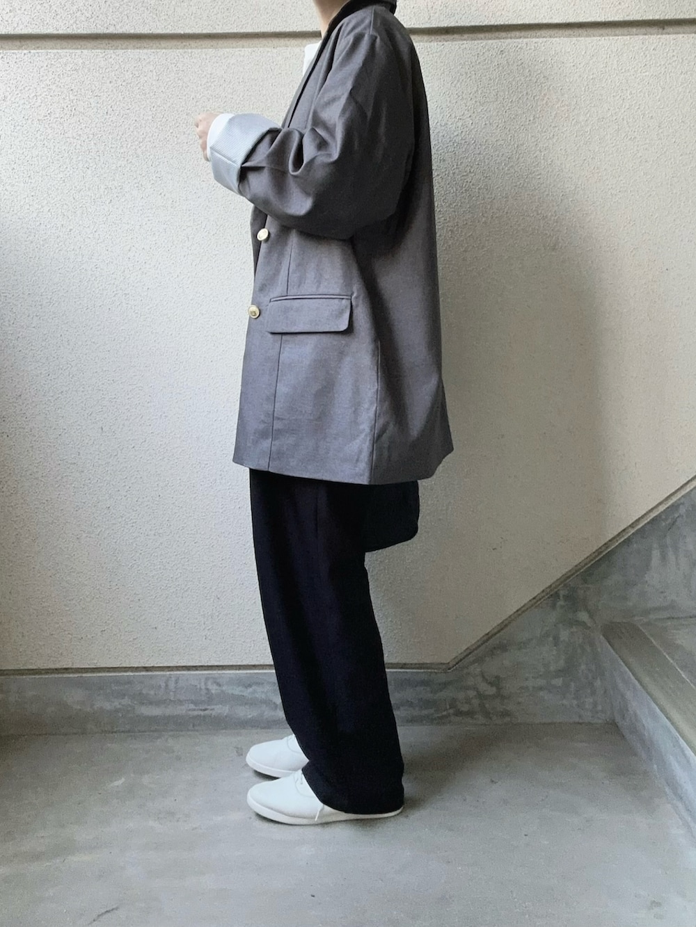 グレー系のテーラードジャケット、ブラック系のボストンバッグを着用したレディースの秋コーディネートの4枚目の写真