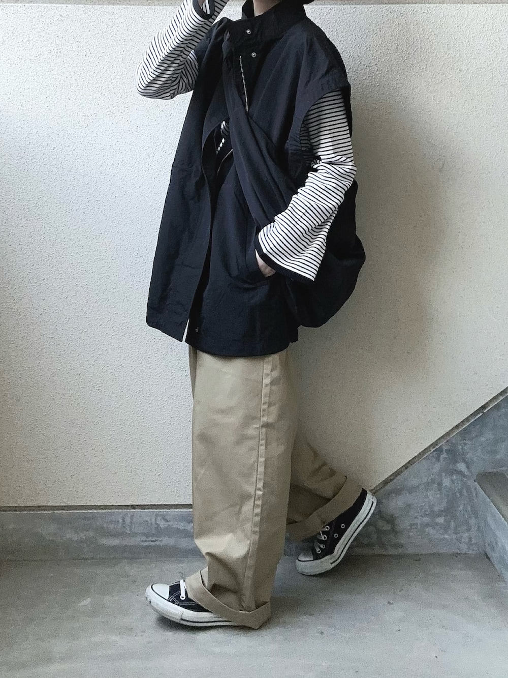 ブラック系のブルゾン、ブラック系のTシャツ/カットソー、ベージュ系のチノパンツを着用したレディースの春コーディネートの3枚目の写真