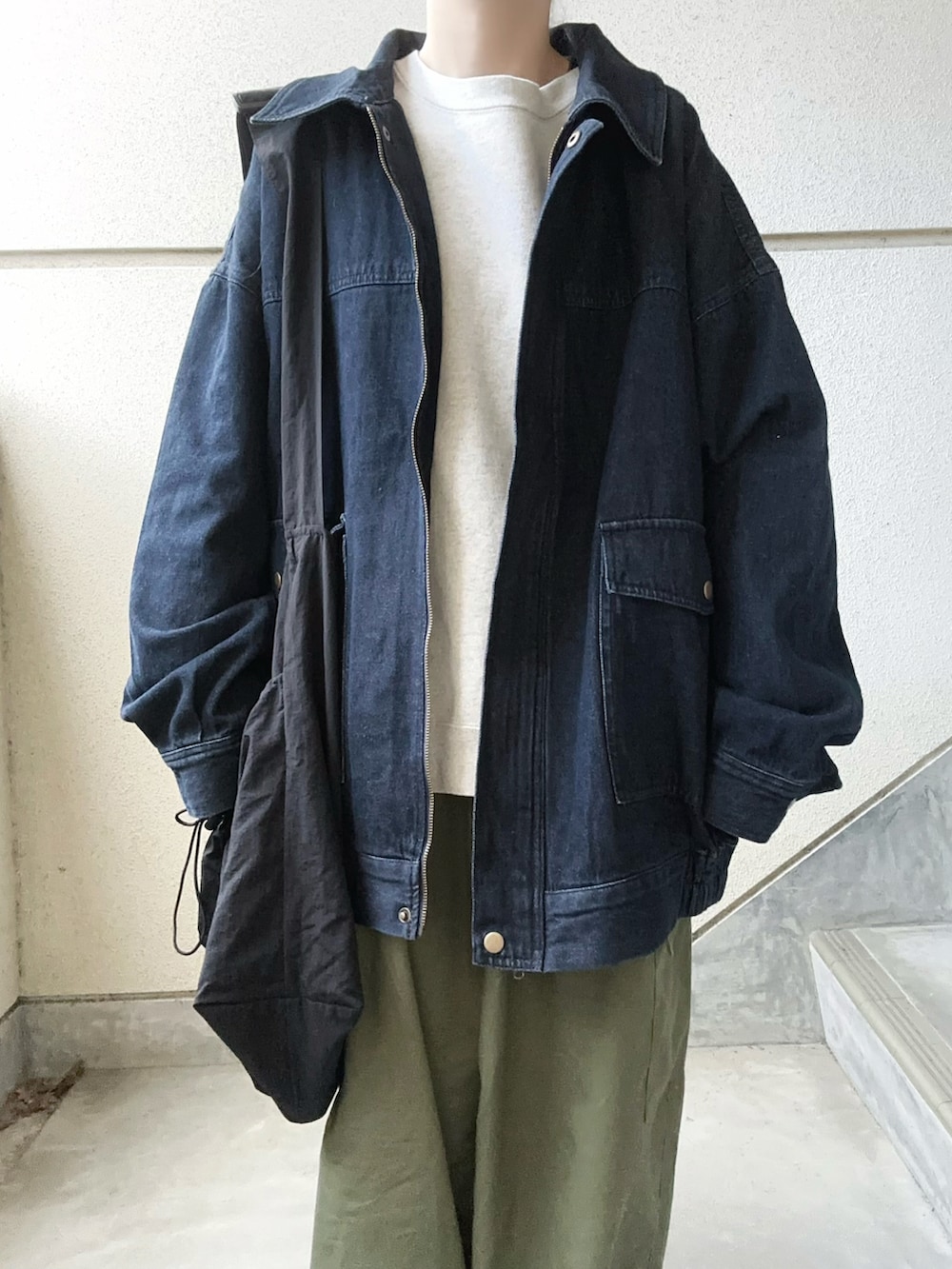 ブルー系のデニムジャケット、グリーン系のカーゴパンツ、ブラック系のショルダーバッグを着用したレディースの春コーディネートの5枚目の写真