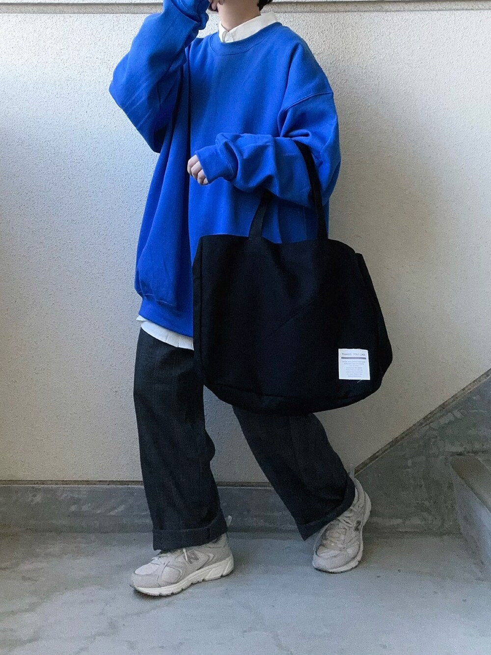 ブラック系のトートバッグ、ホワイト系のシャツ/ブラウス、グレー系のスラックスを着用したレディースの秋コーディネートの2枚目の写真