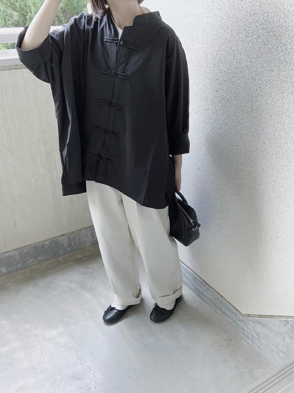 ブラック系のシャツ/ブラウス、ホワイト系のチノパンツ、ブラック系のバレエシューズを着用したレディースの春コーディネートの3枚目の写真