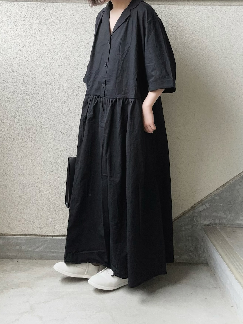 ブラック系のワンピース、ブラック系のスラックス、ホワイト系のスニーカーを着用したレディースの春コーディネートの3枚目の写真