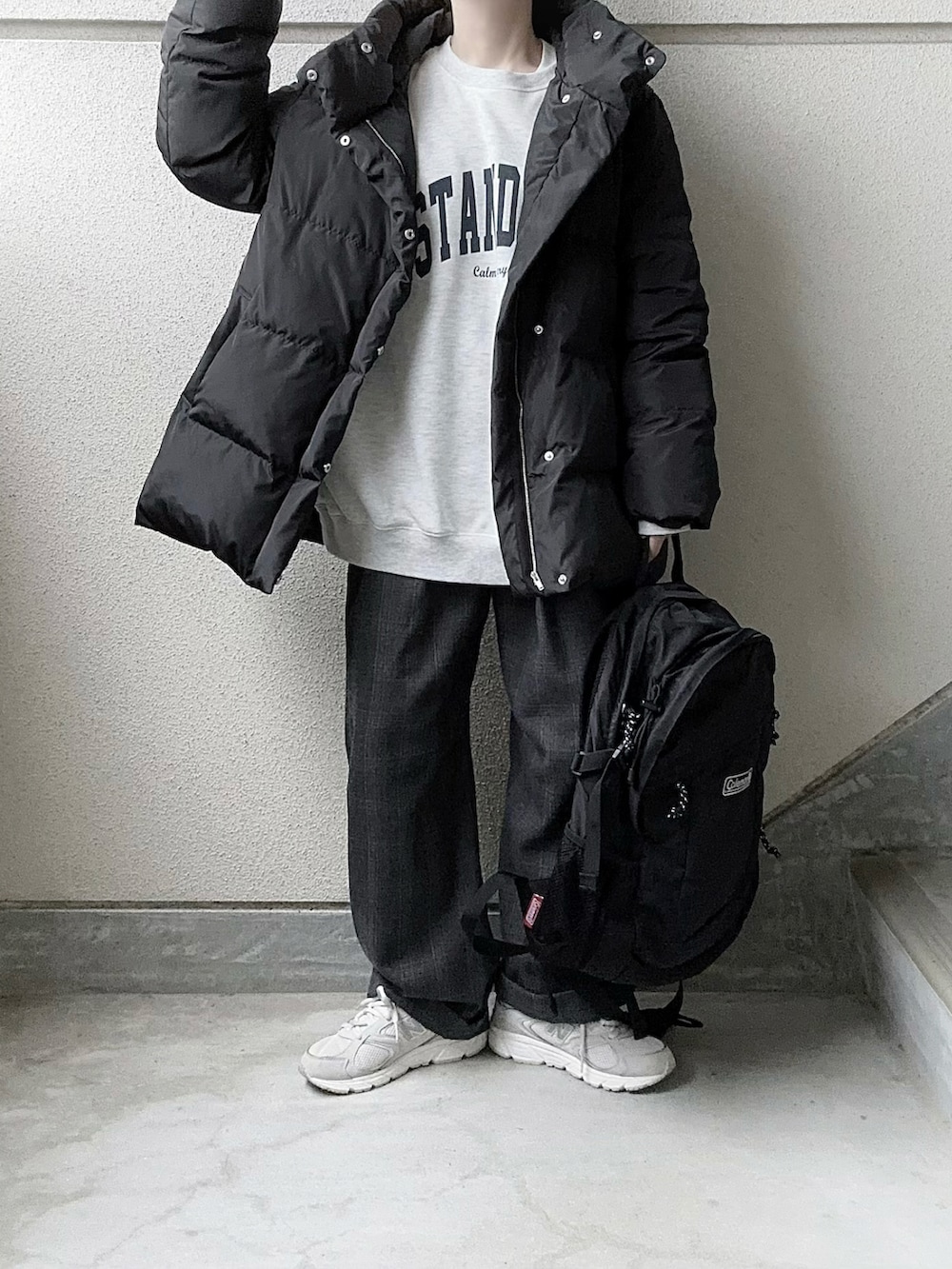 ブラック系のダウンジャケット/コート、ベージュ系のスウェット、グレー系のスラックスを着用したレディースの冬コーディネートの4枚目の写真