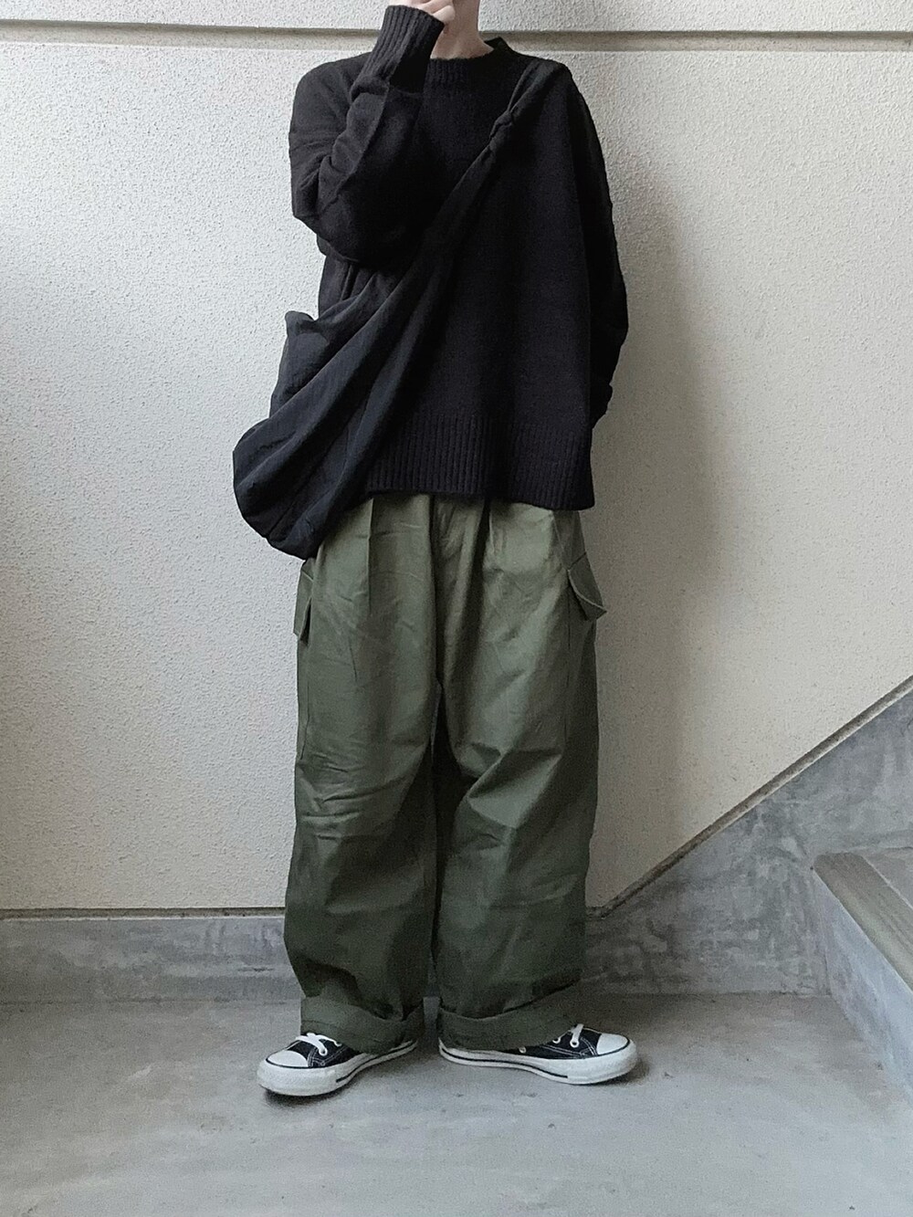 ブラック系のニット/セーター、グリーン系のカーゴパンツを着用したレディースの冬コーディネートの2枚目の写真