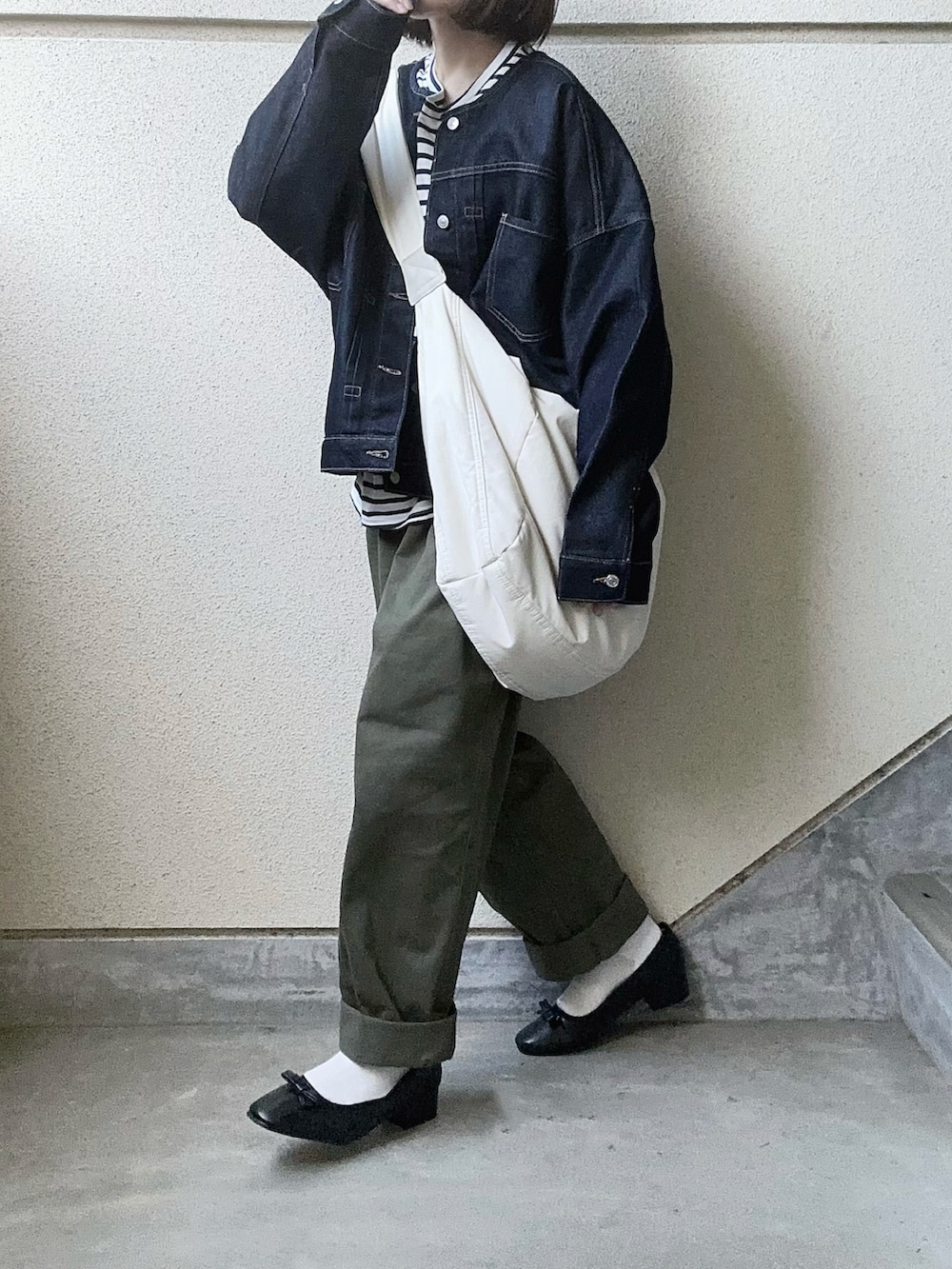 ブラック系のバレエシューズ、ブルー系のデニムジャケット、グリーン系のチノパンツを着用したレディースの夏コーディネートの5枚目の写真