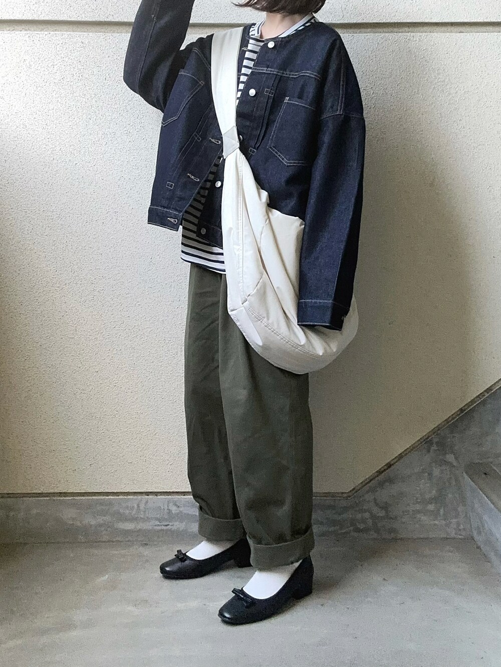 ブラック系のバレエシューズ、ブルー系のデニムジャケット、グリーン系のチノパンツを着用したレディースの夏コーディネートの3枚目の写真