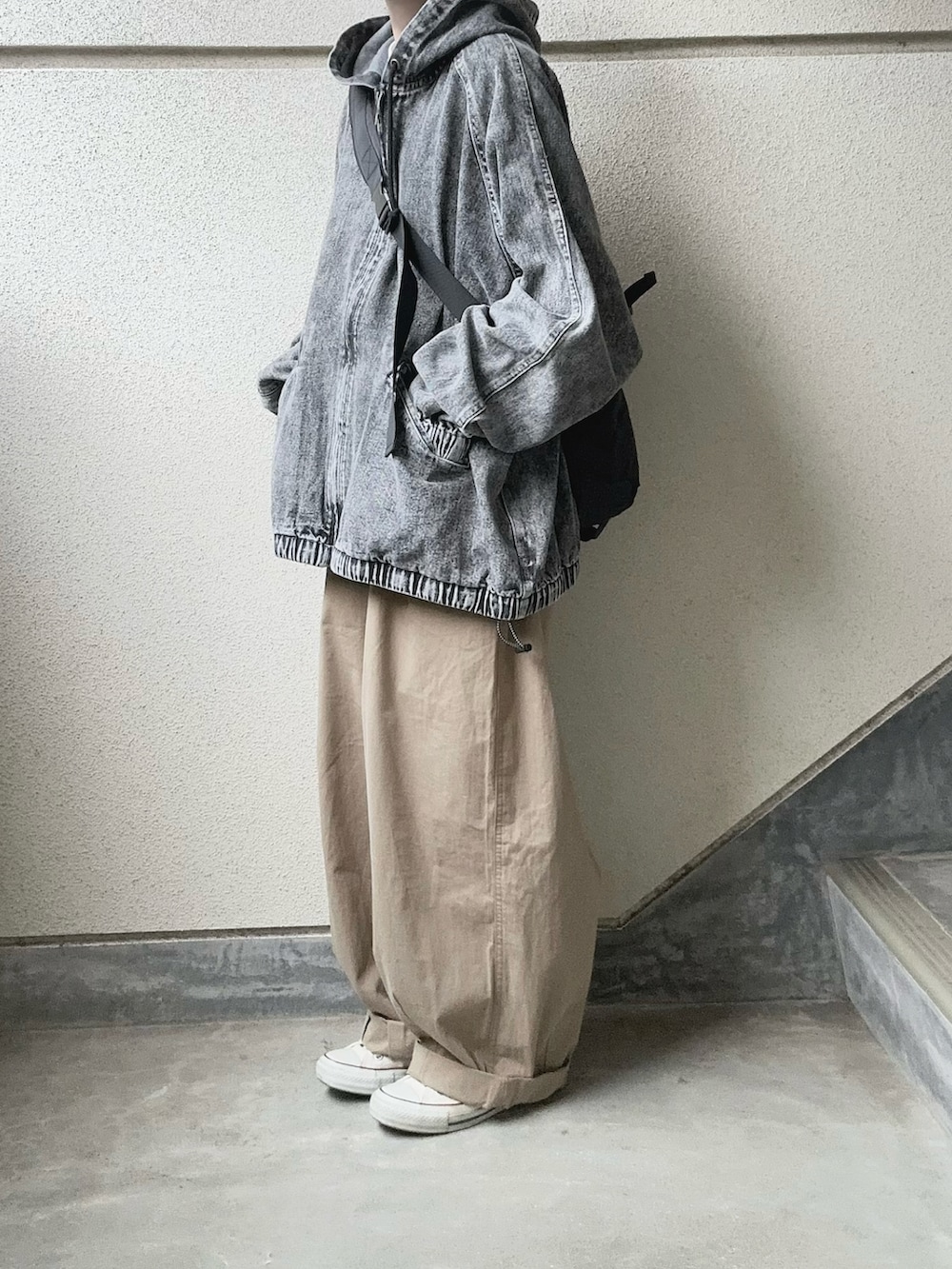 ブラック系のブルゾン、ベージュ系のチノパンツ、ブラック系のボディバッグ/ウエストポーチを着用したレディースの春コーディネートの2枚目の写真