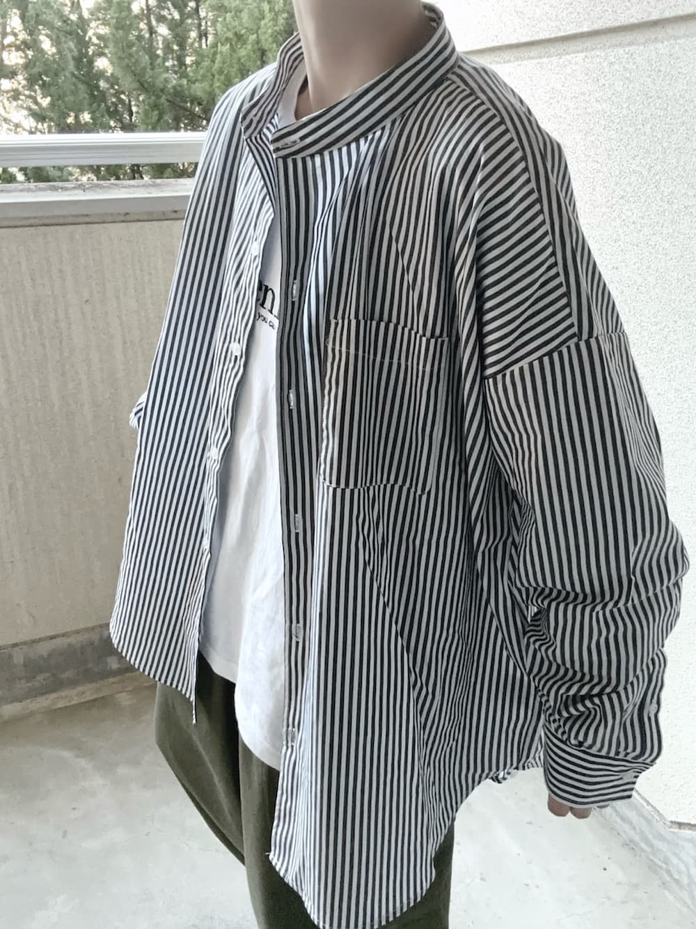 ブラック系のシャツ/ブラウス、ホワイト系のTシャツ/カットソー、グリーン系のカーゴパンツを着用したレディースの春コーディネートの2枚目の写真