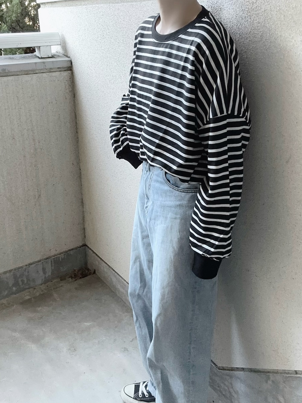 ブラック系のTシャツ/カットソー、ブラック系のショルダーバッグ、ブルー系のデニムパンツを着用したレディースの冬コーディネートの3枚目の写真