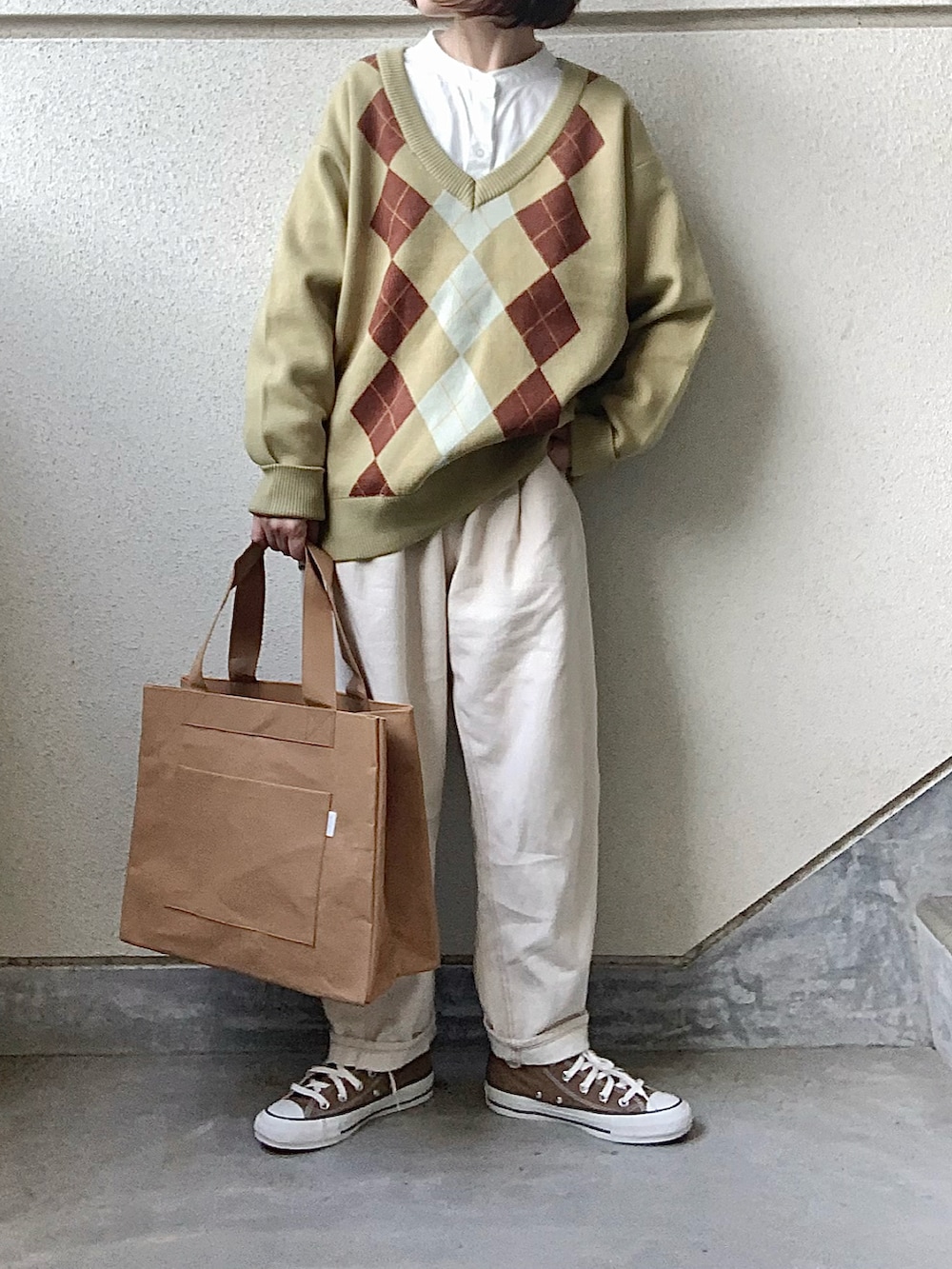 グリーン系のニット/セーター、ベージュ系のトートバッグ、ブラウン系のスニーカーを着用したレディースの冬コーディネートの3枚目の写真