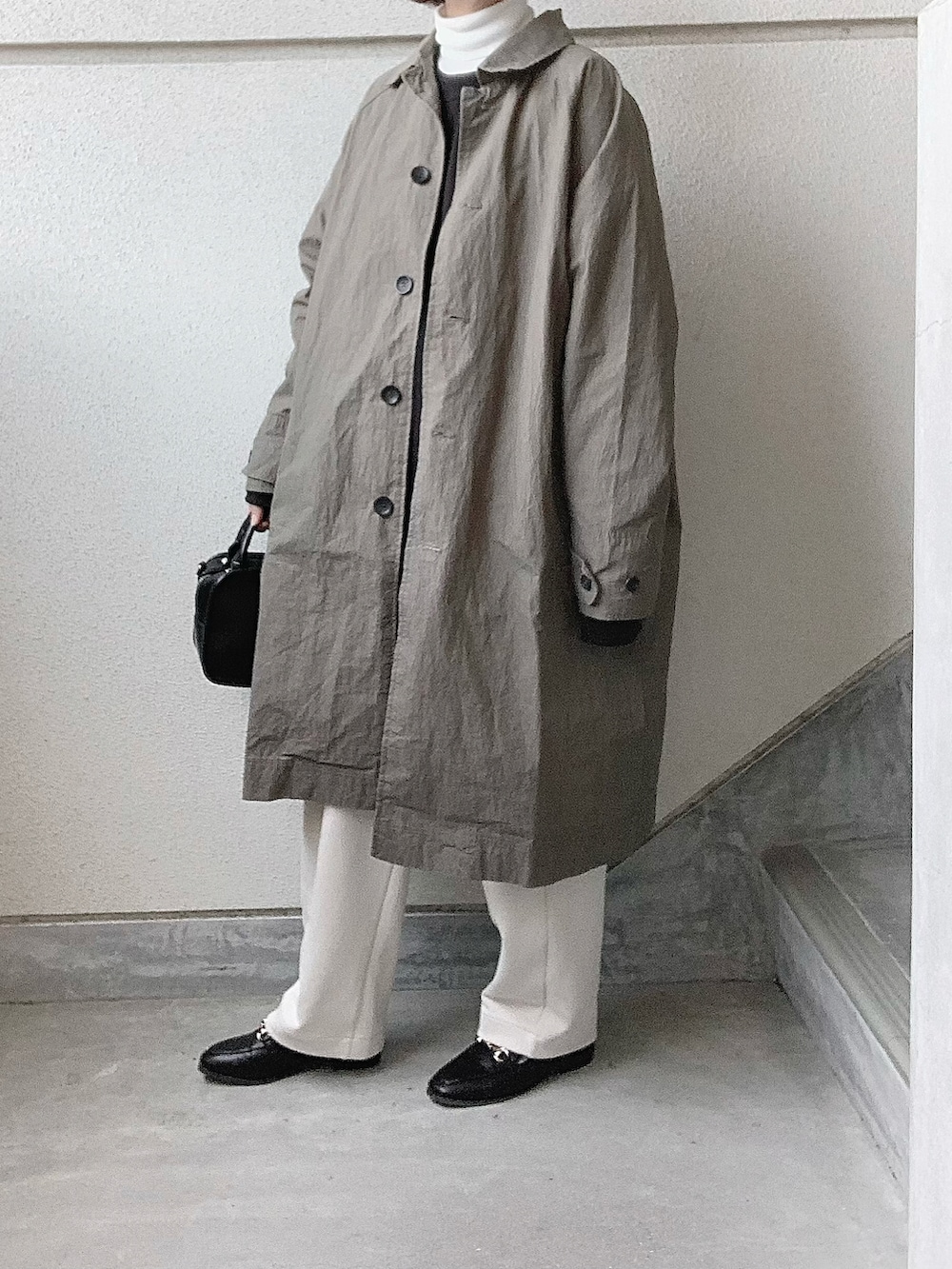 ブラウン系のステンカラーコート、ホワイト系のスウェットパンツ、ホワイト系のTシャツ/カットソーを着用したレディースの冬コーディネートの2枚目の写真