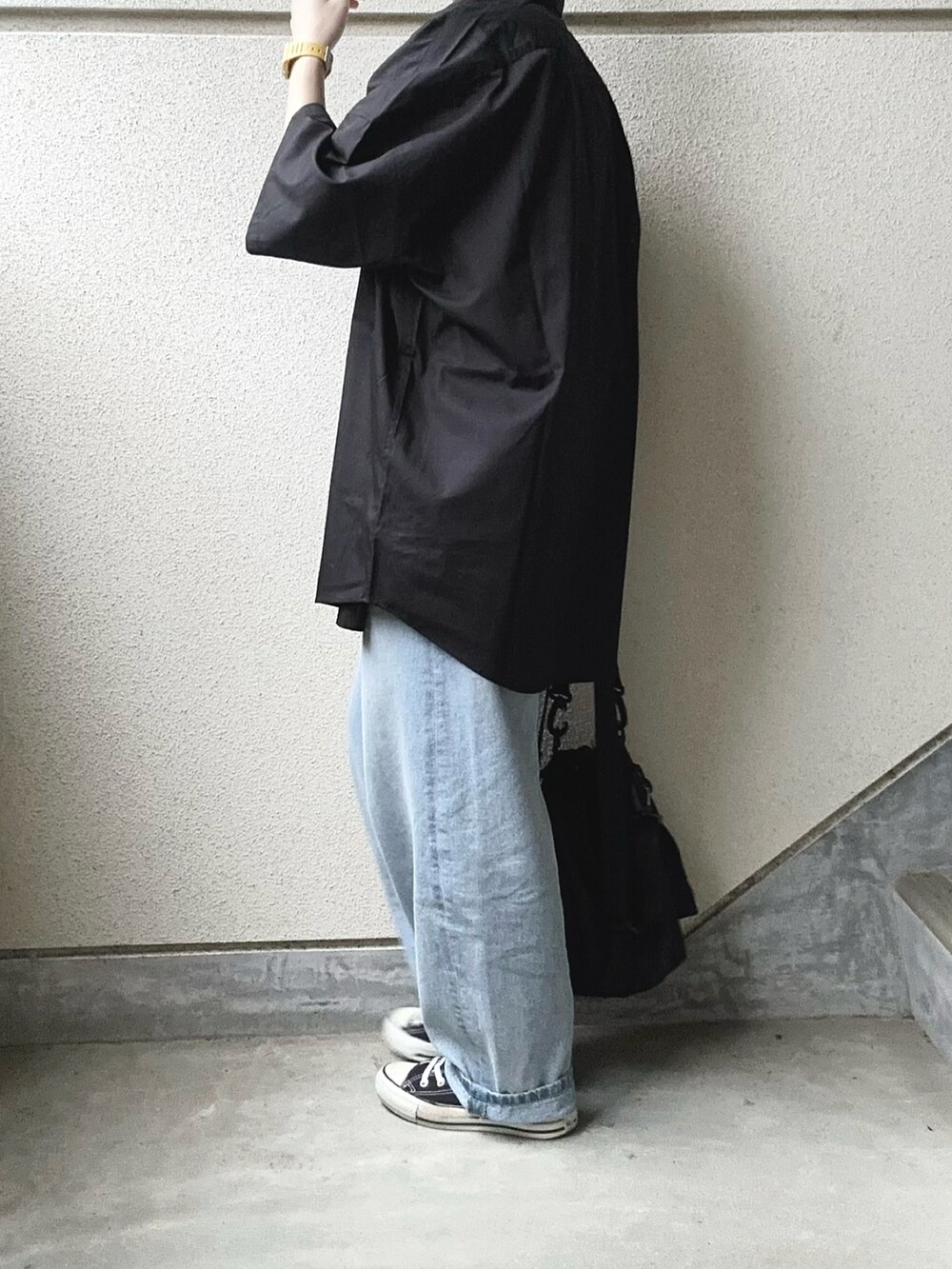 ブラック系のシャツ/ブラウス、ブラック系のショルダーバッグ、ブルー系のデニムパンツを着用したレディースの春コーディネートの2枚目の写真