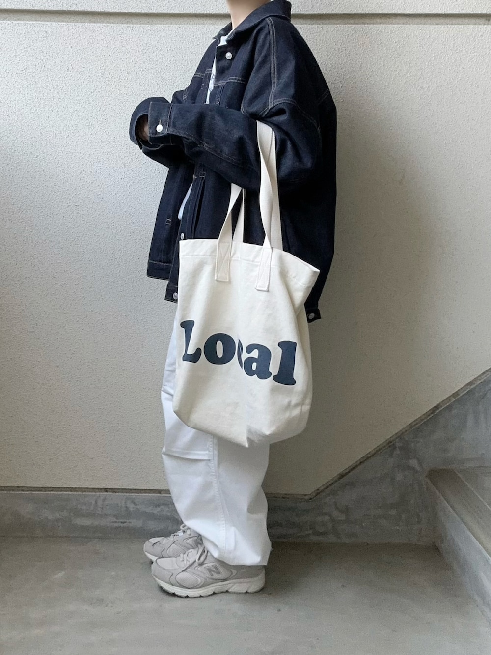 ホワイト系のカーゴパンツ、ブルー系のデニムジャケット、グレー系のスニーカーを着用したレディースの冬コーディネートの3枚目の写真