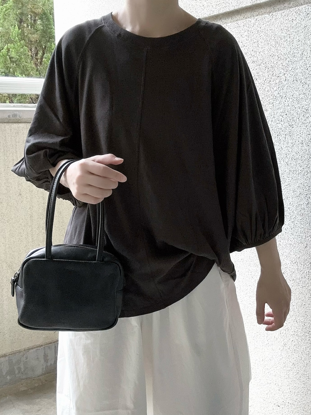 ブラック系のTシャツ/カットソー、ホワイト系のチノパンツを着用したレディースの夏コーディネートの2枚目の写真