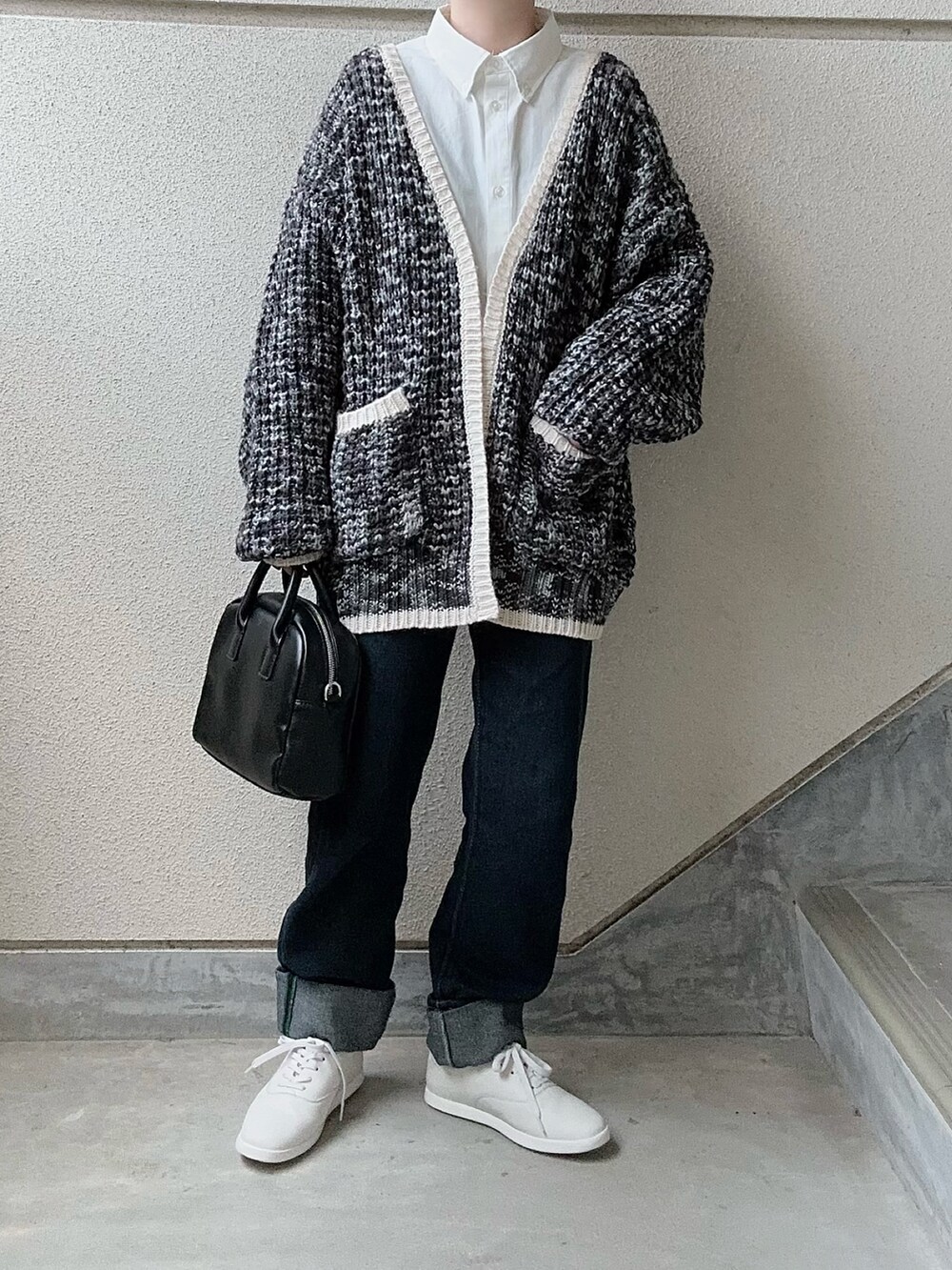 ブラック系のカーディガン/ボレロ、ホワイト系のシャツ/ブラウス、ブルー系のデニムパンツを着用したレディースの冬コーディネートの4枚目の写真