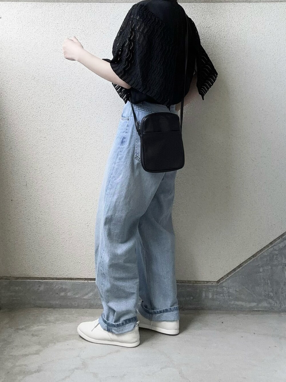 ブラック系のTシャツ/カットソー、ブルー系のデニムパンツ、ホワイト系のスニーカーを着用したレディースの春コーディネートの4枚目の写真