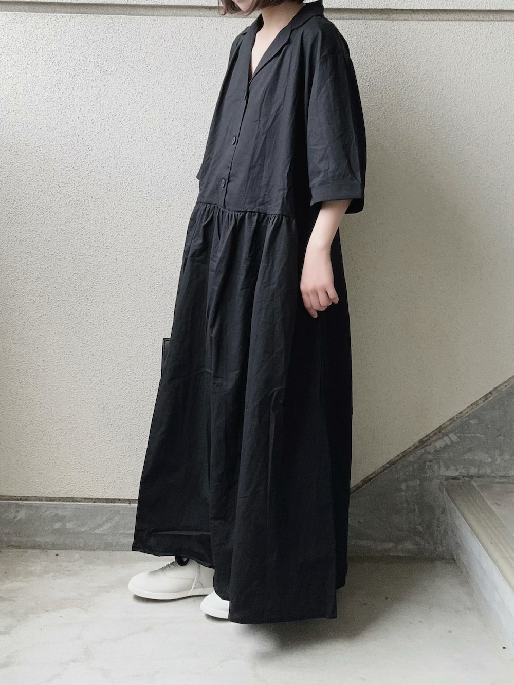 ブラック系のワンピース、ブラック系のスラックス、ホワイト系のスニーカーを着用したレディースの春コーディネートの2枚目の写真