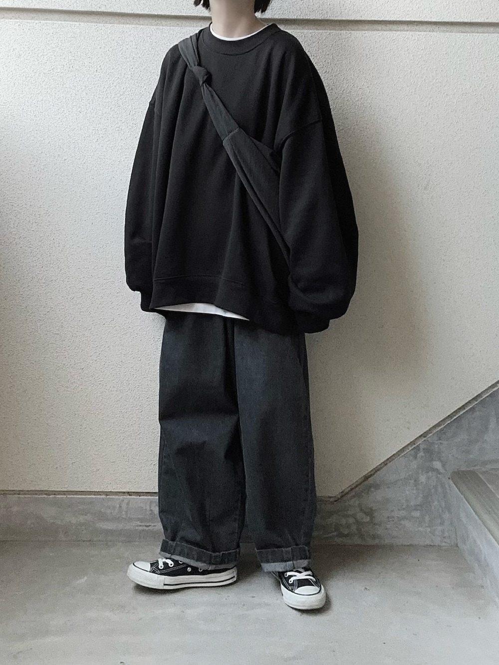 グレー系のデニムパンツ、ブラック系のスウェット、ホワイト系のTシャツ/カットソーを着用したレディースの秋コーディネートの4枚目の写真