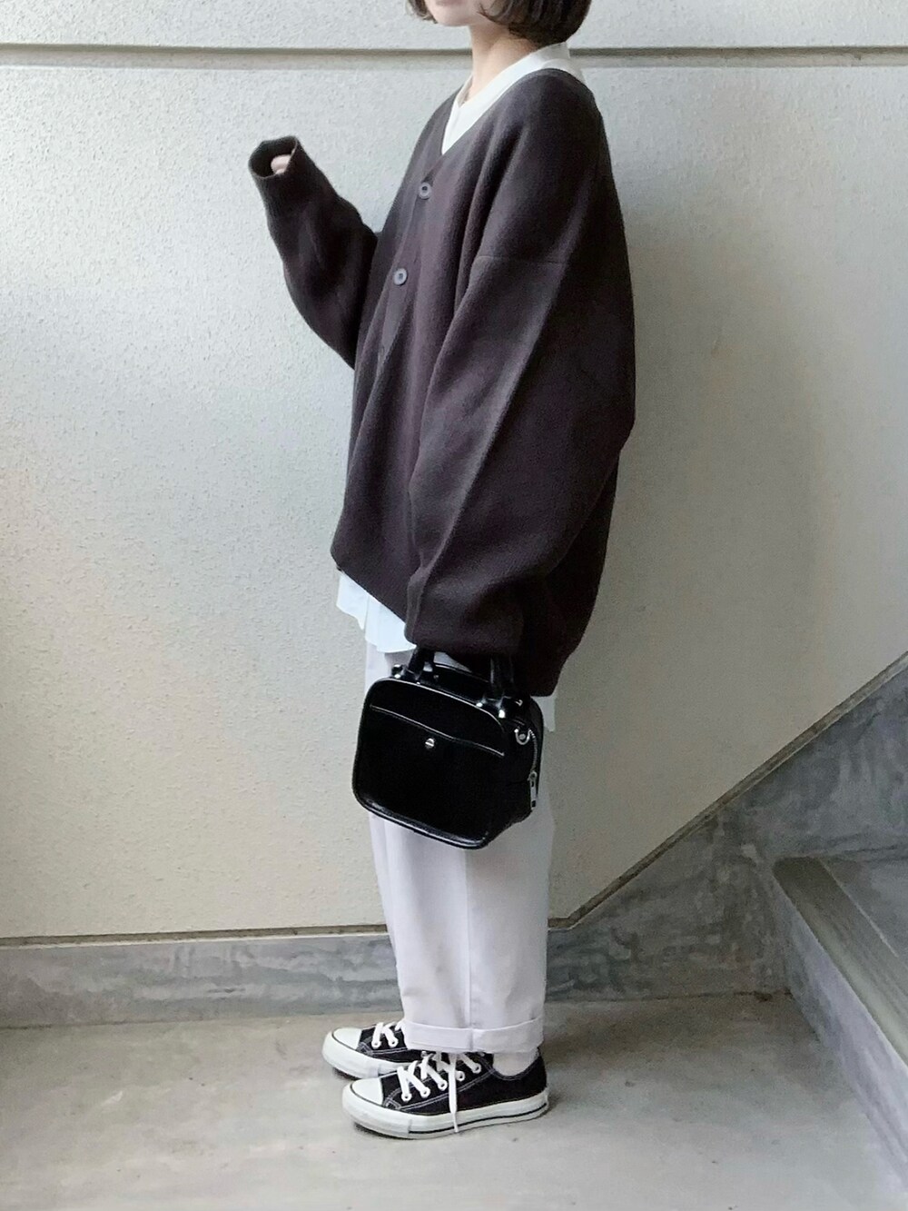 グレー系のカーディガン/ボレロ、ホワイト系のその他パンツ、ブラック系のスニーカーを着用したレディースの冬コーディネートの4枚目の写真