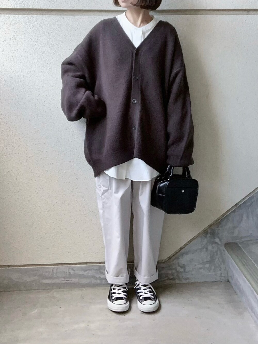 グレー系のカーディガン/ボレロ、ホワイト系のその他パンツ、ブラック系のスニーカーを着用したレディースの冬コーディネートの3枚目の写真