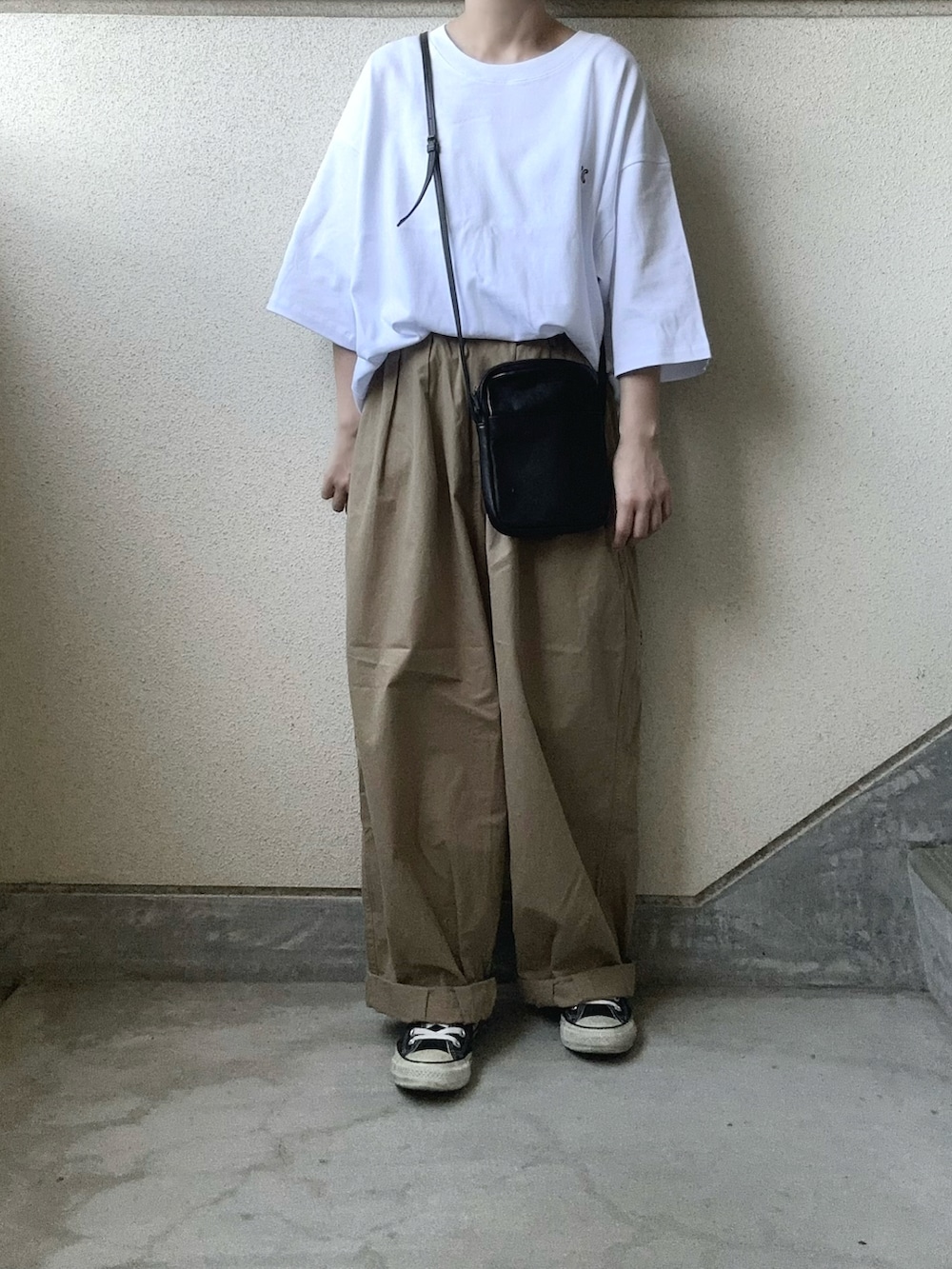 ホワイト系のTシャツ/カットソー、ベージュ系のチノパンツ、ブラック系のショルダーバッグを着用したレディースの夏コーディネートの4枚目の写真
