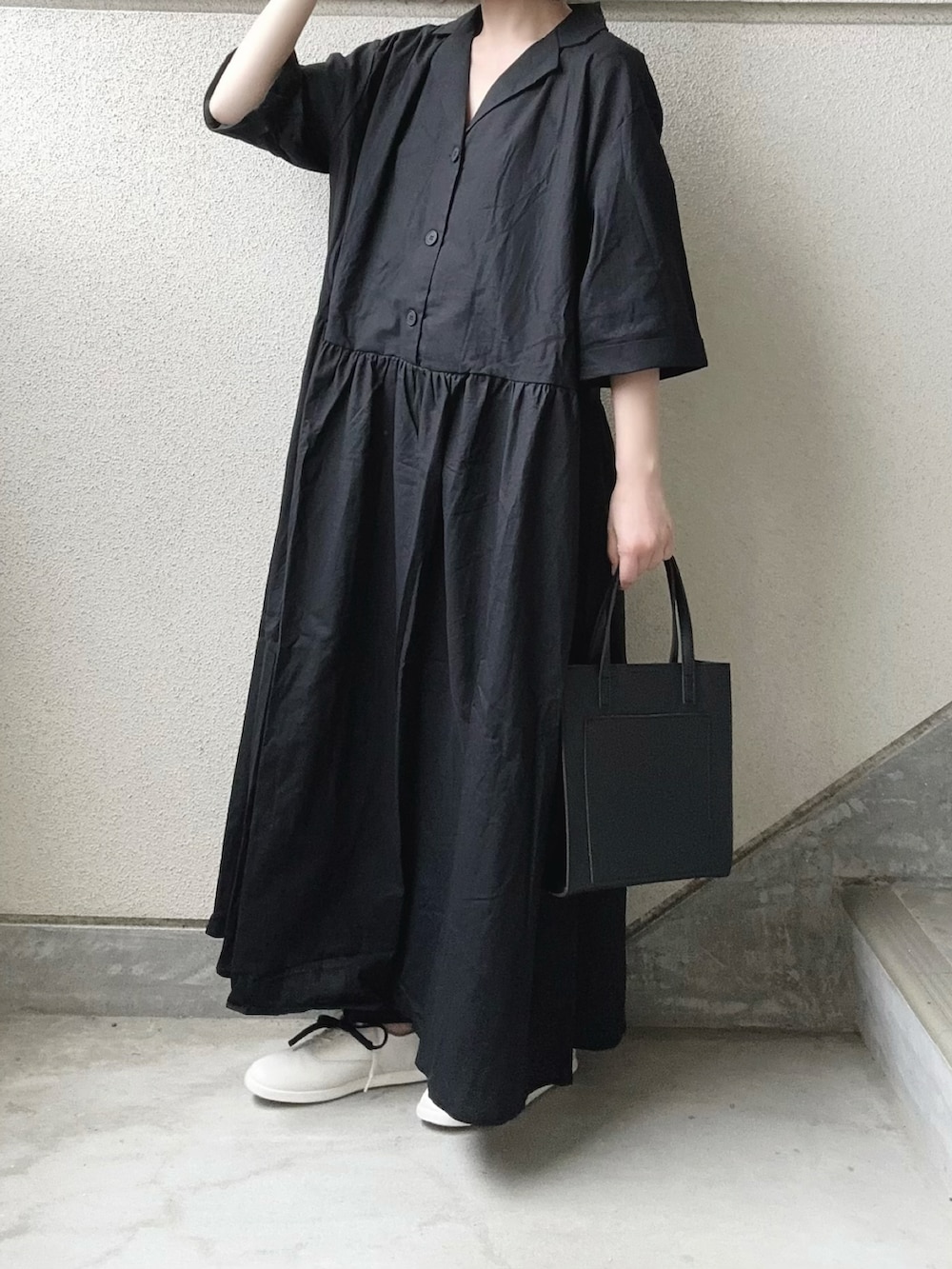 ブラック系のワンピース、ブラック系のスラックス、ホワイト系のスニーカーを着用したレディースの春コーディネートの4枚目の写真