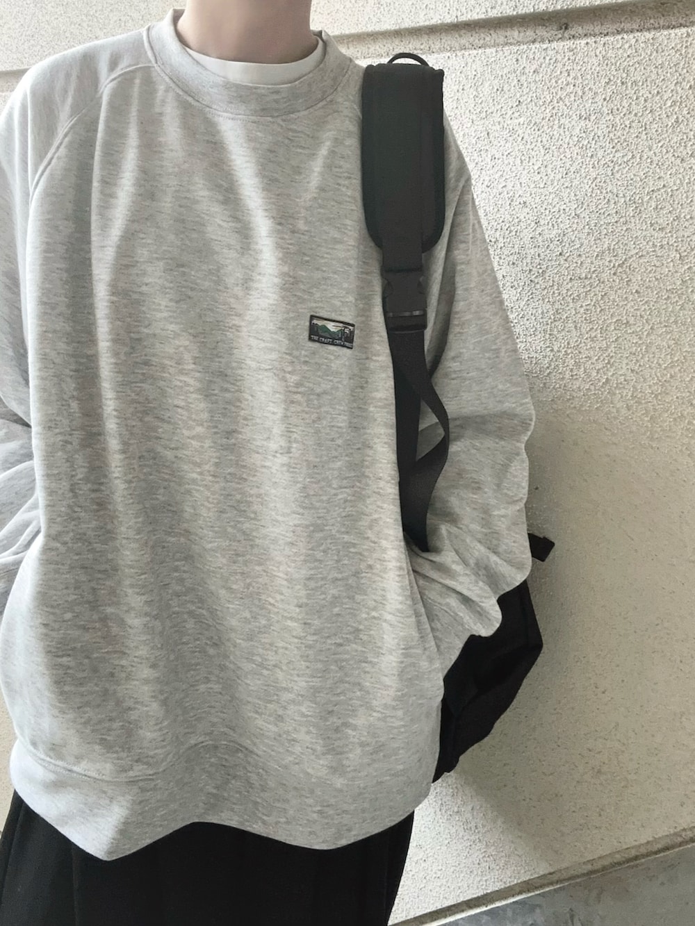 グレー系のスウェット、ブラック系のボディバッグ/ウエストポーチ、ブラック系のスラックスを着用したレディースの冬コーディネートの5枚目の写真