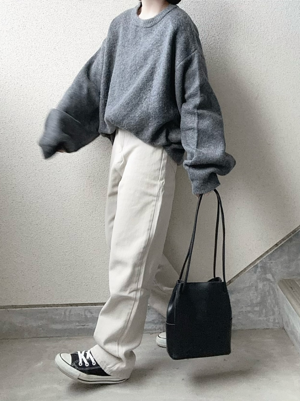 グレー系のニット/セーター、グレー系のデニムパンツを着用したレディースの冬コーディネートの4枚目の写真