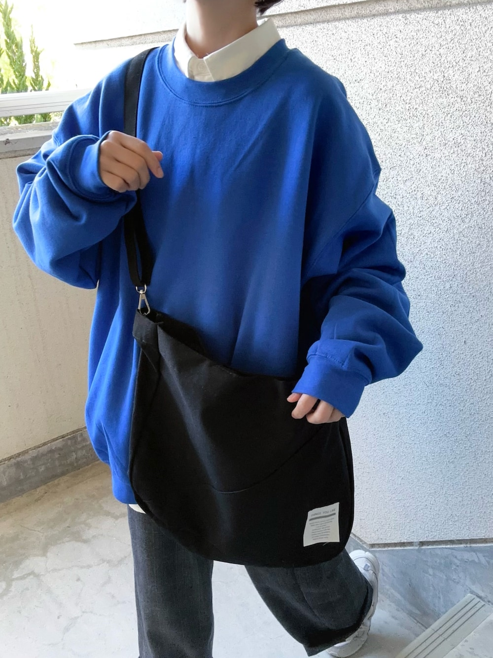 ブラック系のトートバッグ、ホワイト系のシャツ/ブラウス、グレー系のスラックスを着用したレディースの秋コーディネートの5枚目の写真