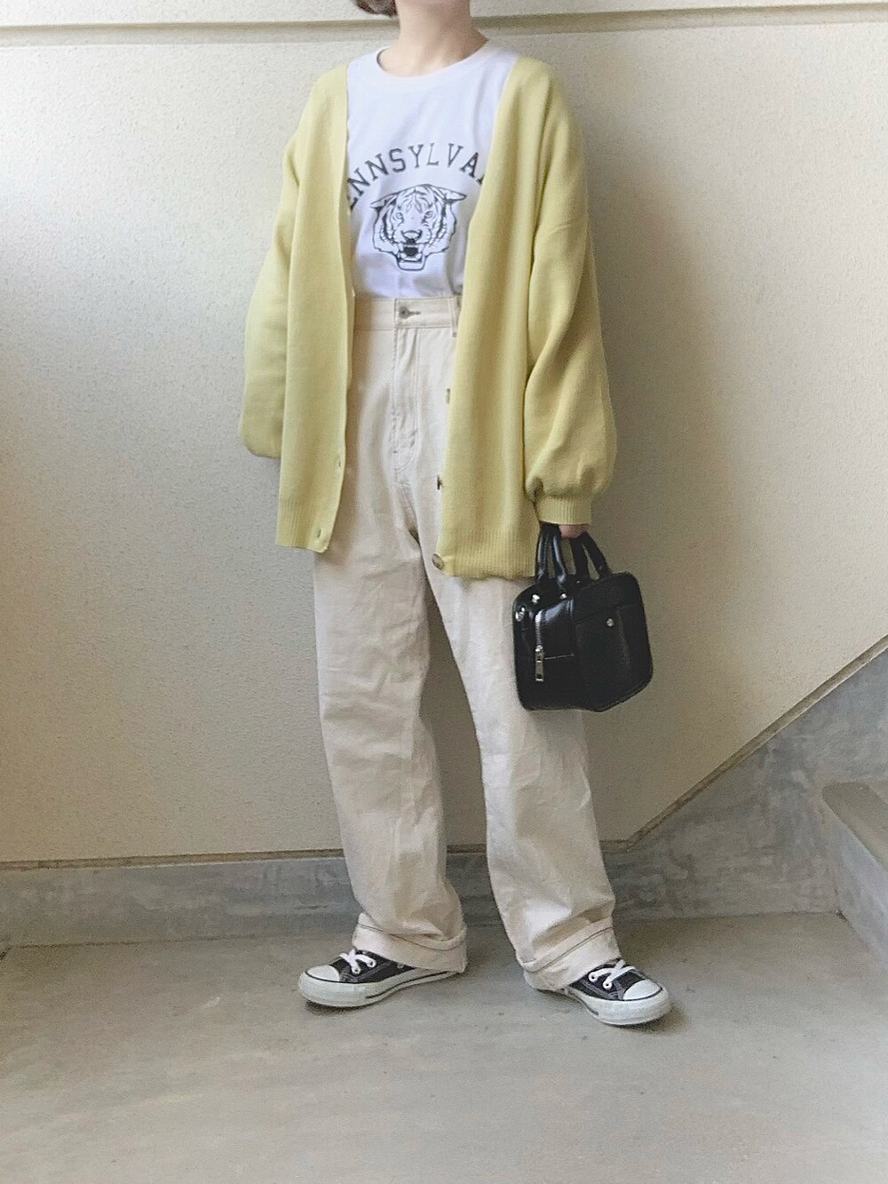 イエロー系のカーディガン/ボレロ、ホワイト系のTシャツ/カットソー、ホワイト系のデニムパンツを着用したレディースの冬コーディネートの2枚目の写真