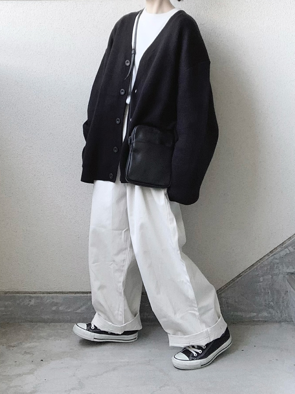 ベージュ系のチノパンツ、ブラック系のカーディガン/ボレロ、ホワイト系のTシャツ/カットソーを着用したレディースの秋コーディネートの4枚目の写真