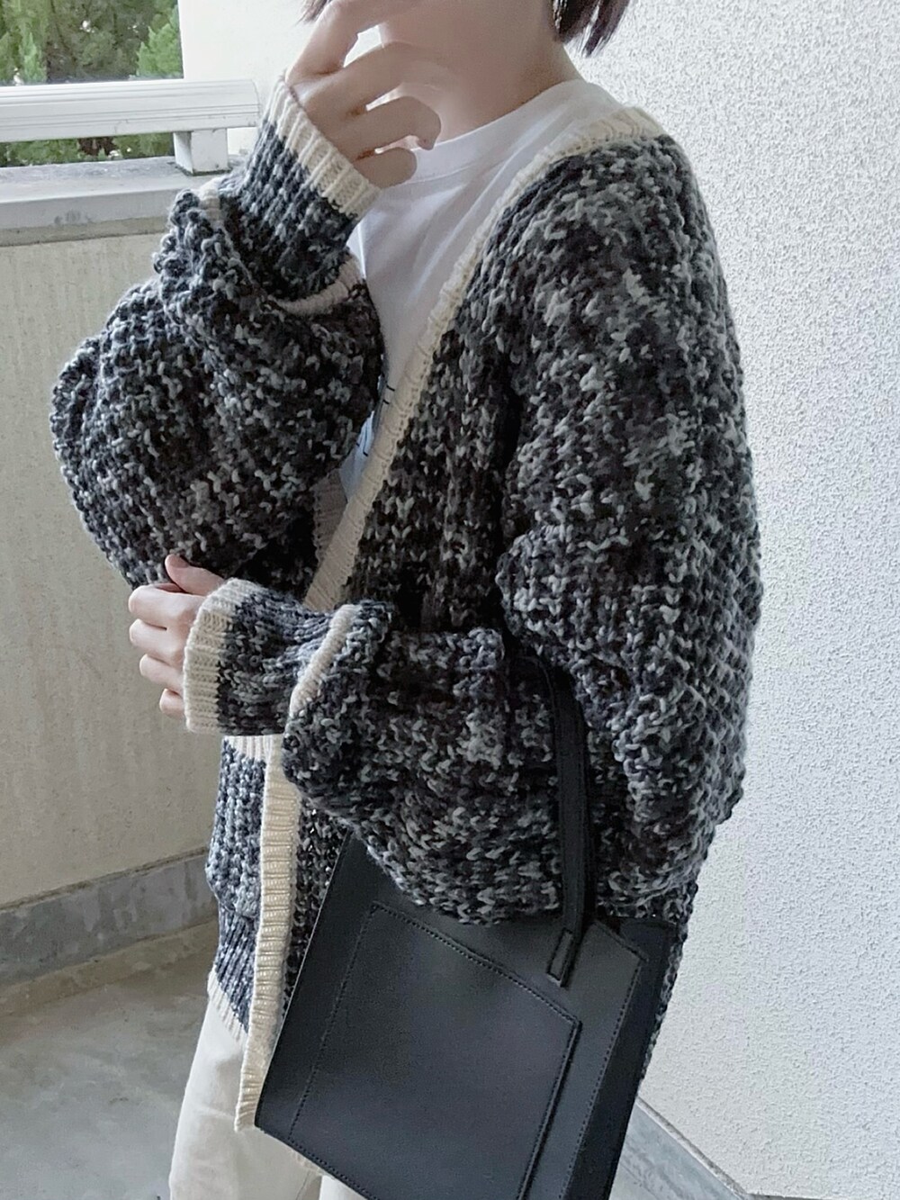 ブラック系のカーディガン/ボレロ、ホワイト系のTシャツ/カットソー、ホワイト系のデニムパンツを着用したレディースの冬コーディネートの3枚目の写真