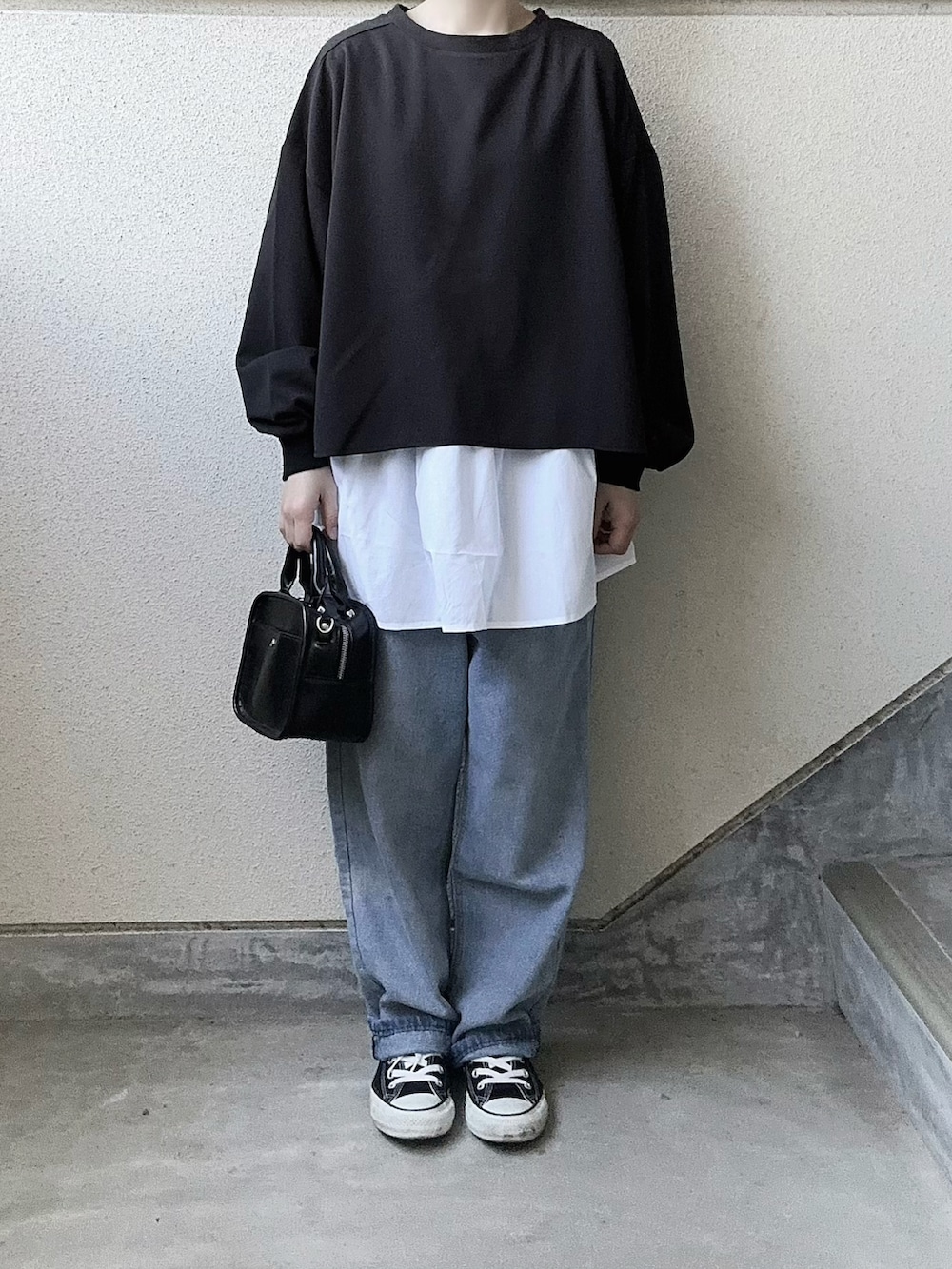 ブラック系のアンサンブルを着用したレディースの春コーディネートの3枚目の写真