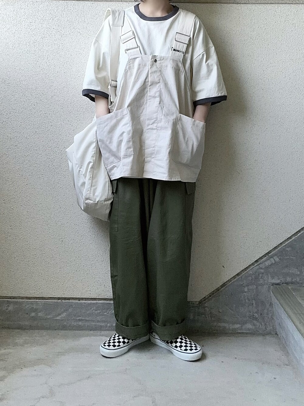 ホワイト系のベスト、グレー系のTシャツ/カットソー、グリーン系のカーゴパンツを着用したレディースの春コーディネートの3枚目の写真