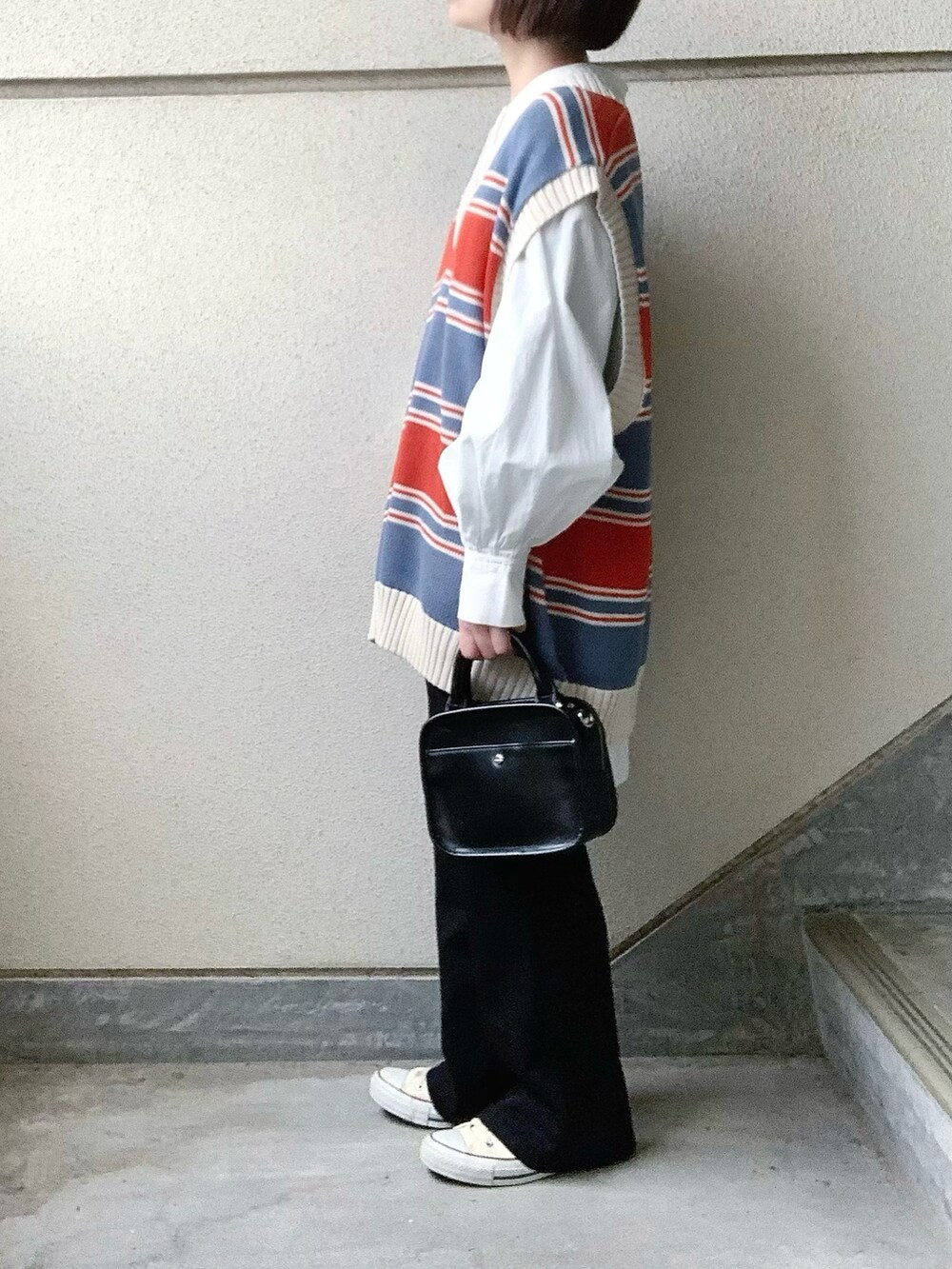 ブルー系のベスト、ブラック系のその他パンツ、ホワイト系のシャツ/ブラウスを着用したレディースの春コーディネートの2枚目の写真